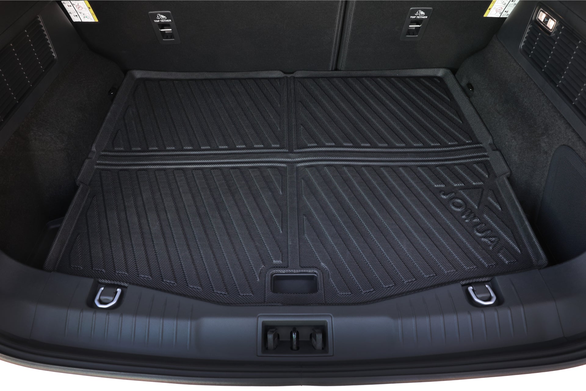 Interior view showcasing the trunk of a Ford Mustang Mach-E fitted with the JOWUA All Weather Trunk Liner. This black, textured mat offers protective coverage with raised edges and grooves. It features visible hooks on the sides, latch points at the back, and a foldable design for adaptable cargo configurations.