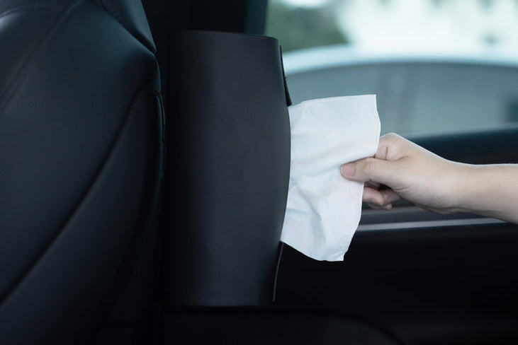 A hand pulls a white tissue from the JOWUA Hook Bundle (Model S/X/3 2024+/Y Juniper 2025+), easily installed and securely attached to the back of a car seat.
