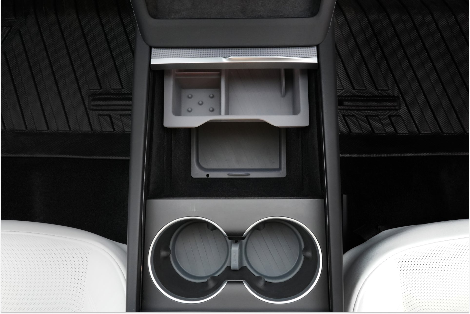 The image showcases the JOWUA LED Center Console Combo for the Tesla Reengineered Model 3 Highland (2024+), featuring an innovative center console system complete with cup holders, an open storage compartment with a sliding cover, and textured rubber mats. The black interior is enhanced by a premium silicone organizer and is complemented by glimpses of white seats on either side.