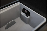 A close-up of the JOWUA Premium Interior Essentials Set – Model Y Juniper in gray, featuring a center console compartment with a built-in port holding a black charging cable with a visible USB-C or Lightning connector.