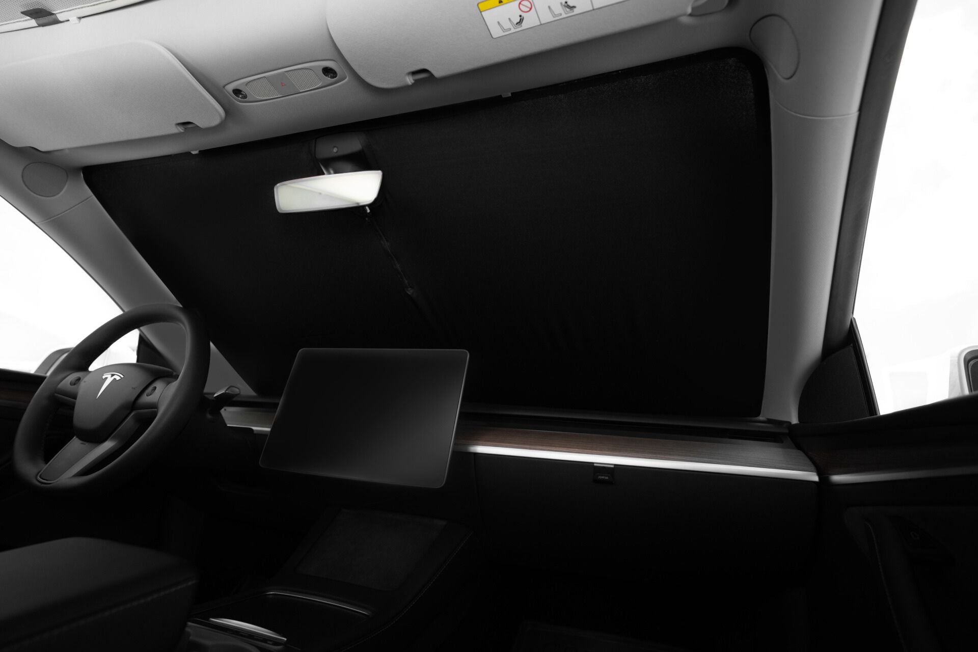 Interior view of a car featuring the JOWUA Windshield Sunshade for Model Y, providing UV protection across the windshield. The steering wheel and a large central screen are visible. The modern interior showcases a minimalist design with easy installation features for seamless use.