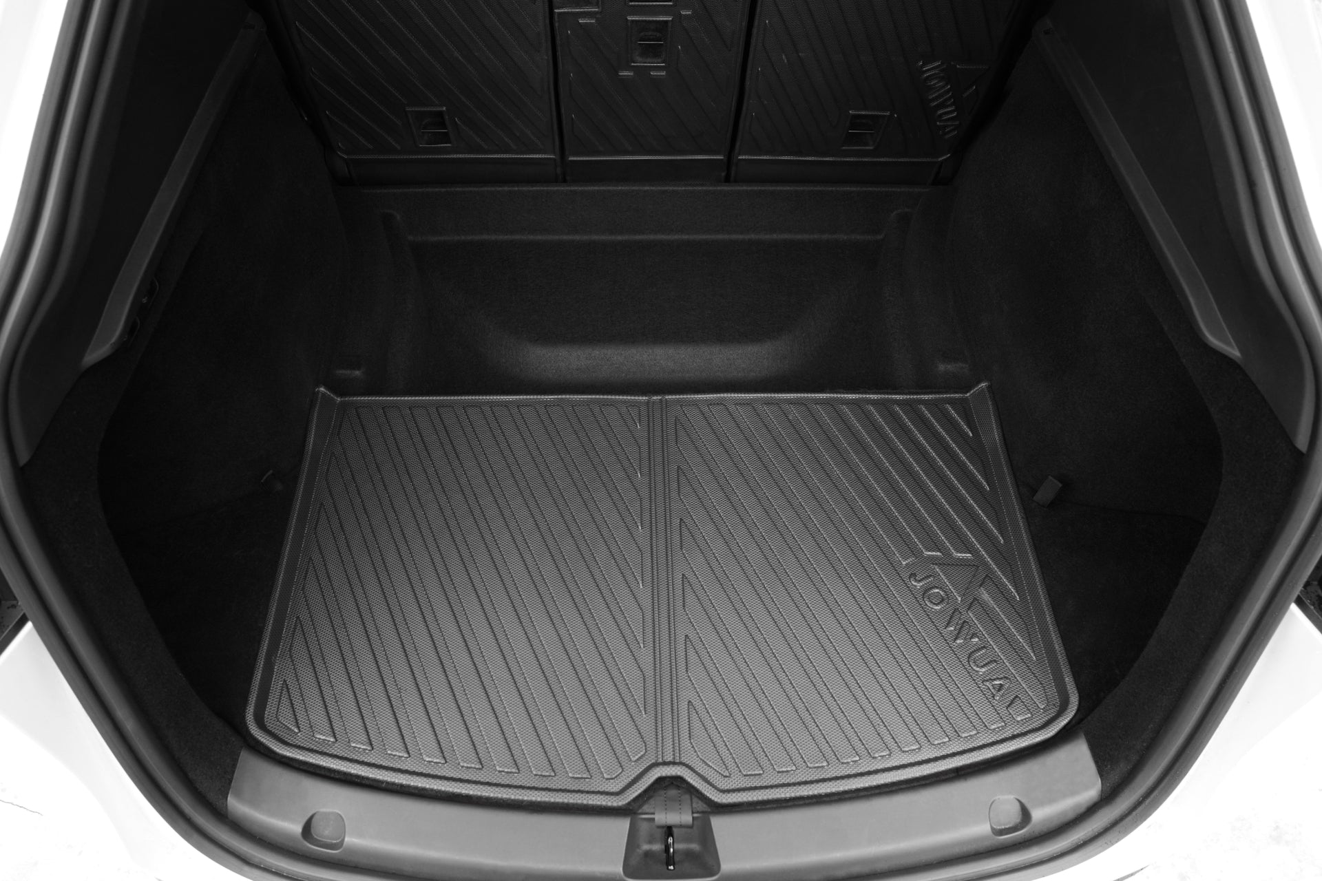 The image shows the empty trunk of a Tesla Model Y fitted with a JOWUA Model Y EasyShield Waterproof Trunk Liner + Rear Seats Back Cover Bundle, featuring raised edges and diagonal grooves for all-weather protection.