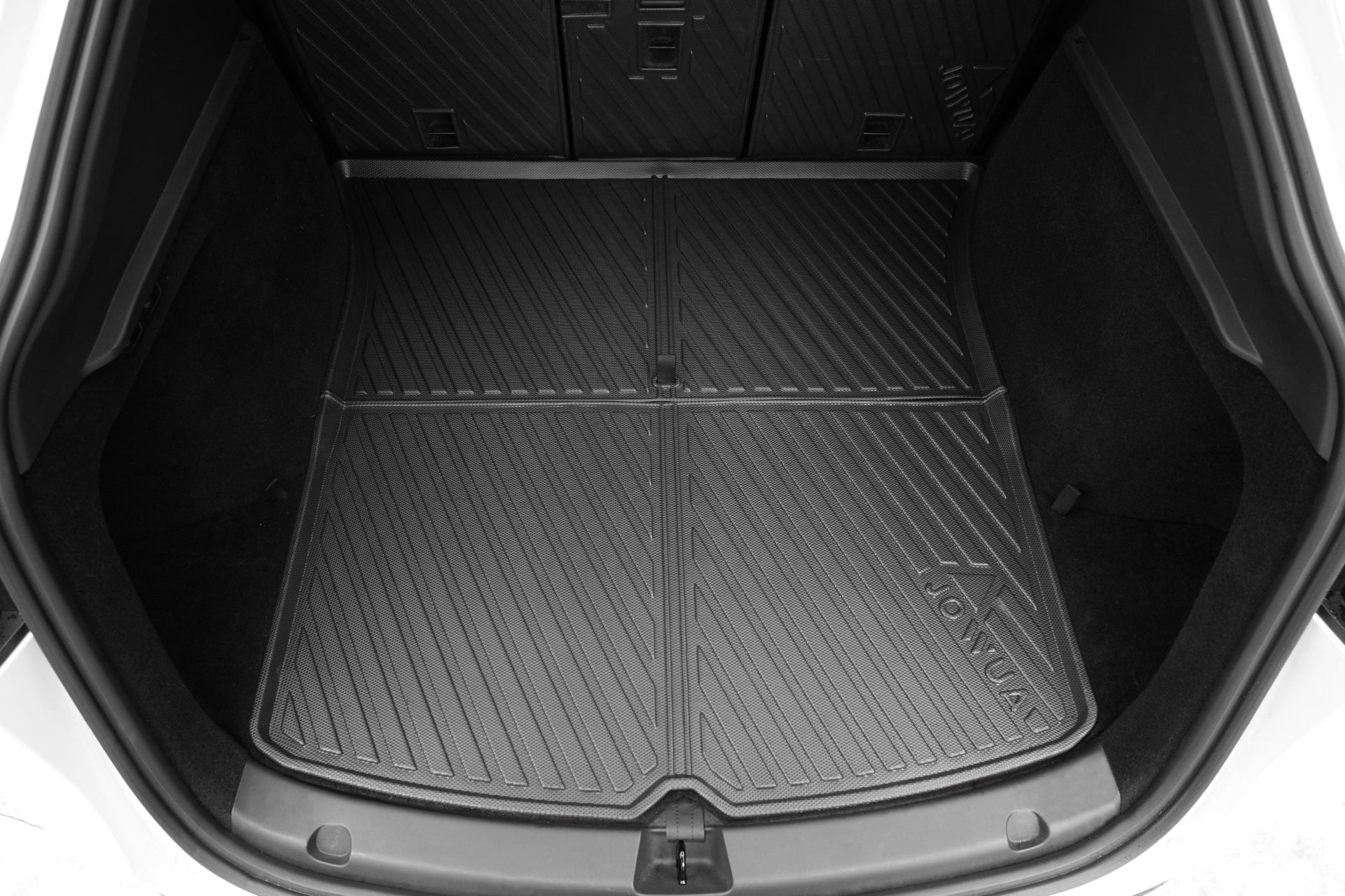 A close-up of a Model Y EasyShield Waterproof Trunk Liner + Rear Seats Back Cover Bundle (Juniper 2025+/2018-2024) by JOWUA, showing its fitted, textured black design with diagonal grooves in the car trunk.