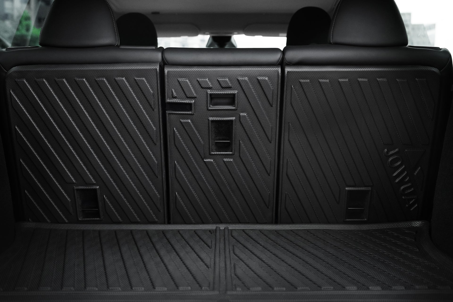 Close-up of JOWUA Model Y EasyShield Waterproof Trunk Liner + Rear Seats Back Cover Bundle (Juniper 2025+/2018-2024), showing black textured seatbacks with geometric patterns and a folded-down liner.