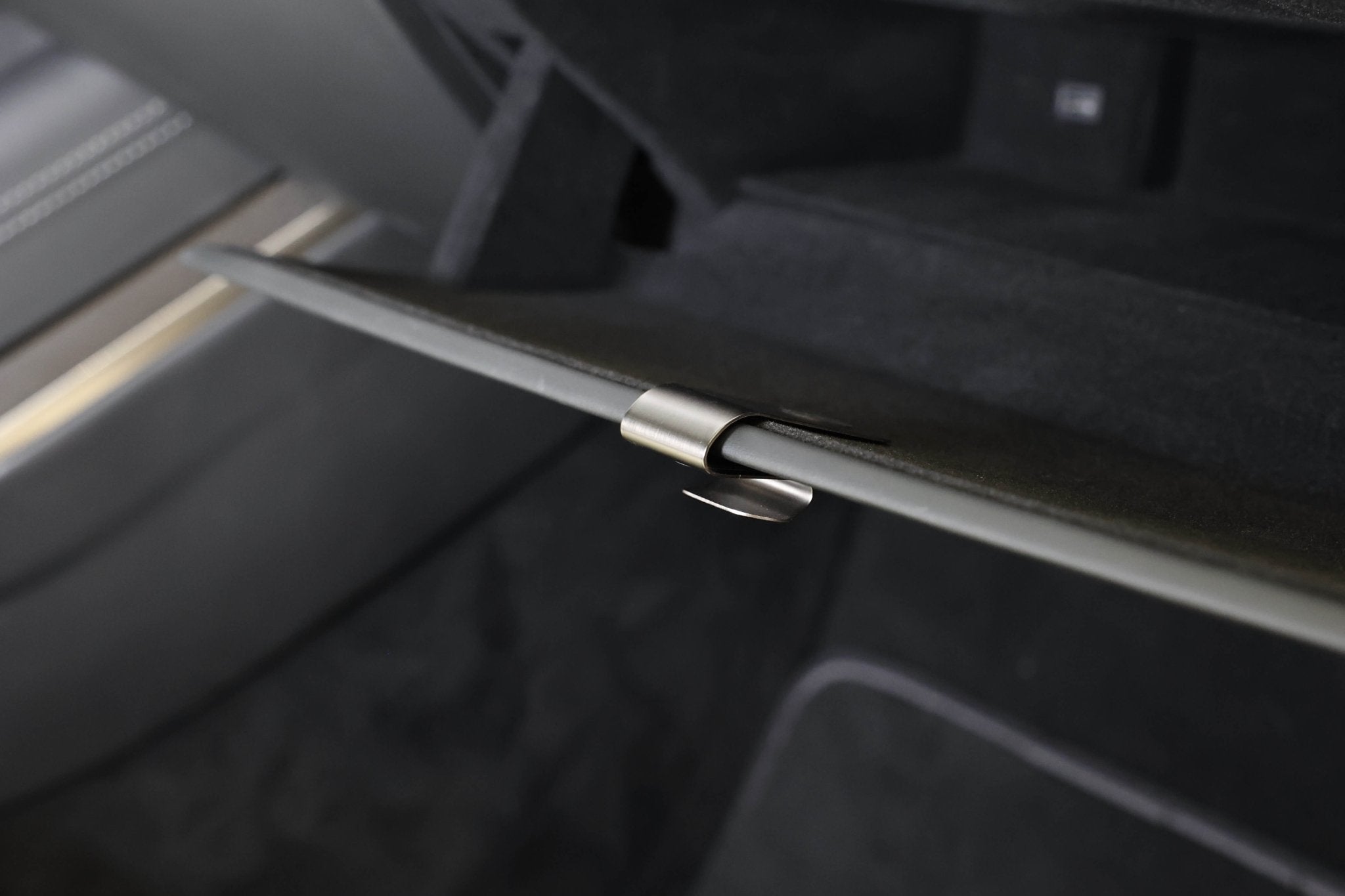 A close-up shows a slightly open Tesla glove compartment, featuring a stainless steel latch. The space is lined with dark fabric for easy installation of the JOWUA Glovebox Hook (Model S/X/3 Highland 2024+, Model Y Juniper 2025+), with edges aligned to the dashboard.