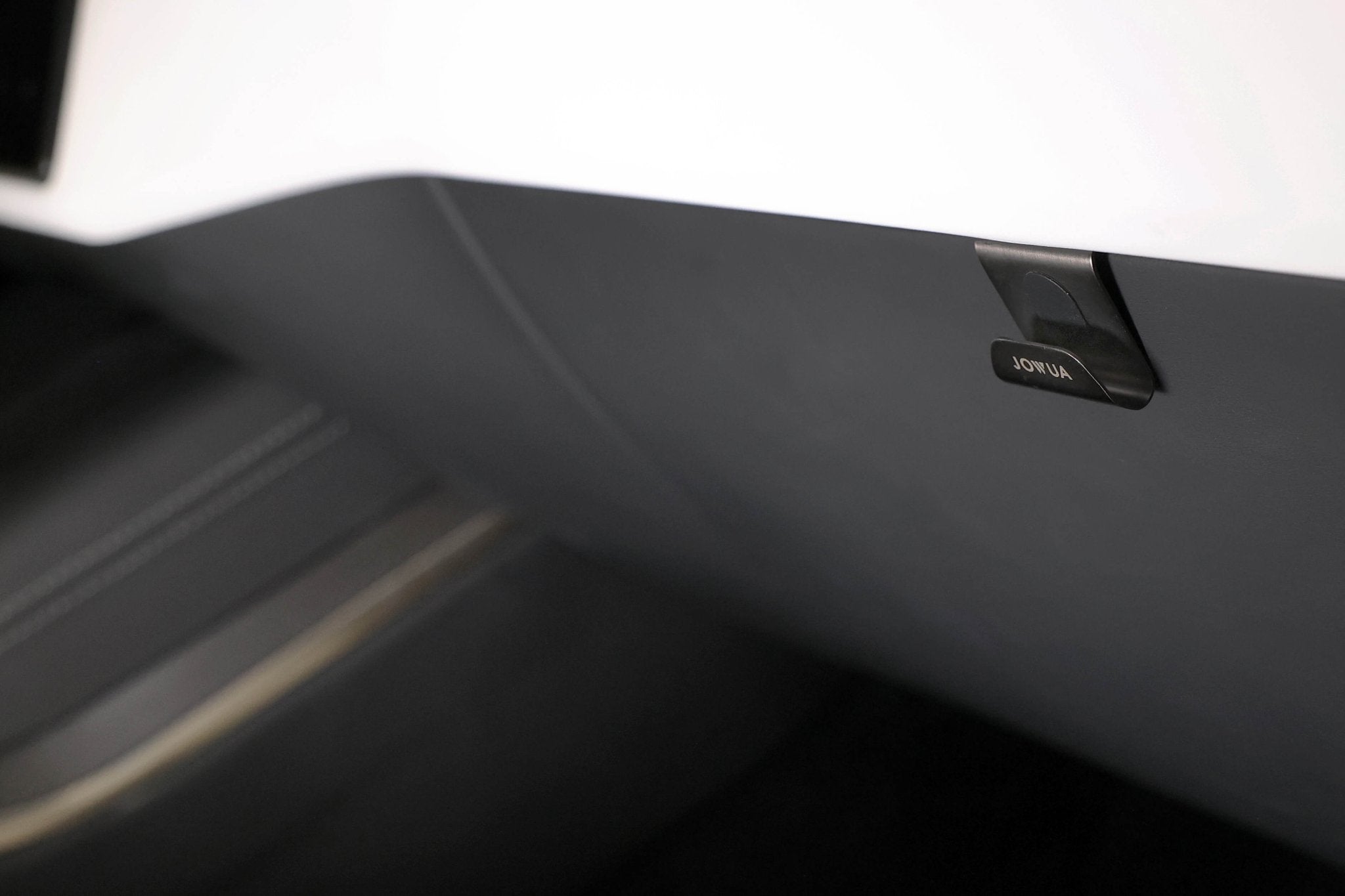 Close-up of a car's dark interior glove compartment featuring a JOWUA Glovebox Hook for Tesla Model S/X/3 Highland (2024+)/Y Juniper (2025+). A small "OPEN" latch/button is visible on the right, ensuring easy installation and seamless integration.