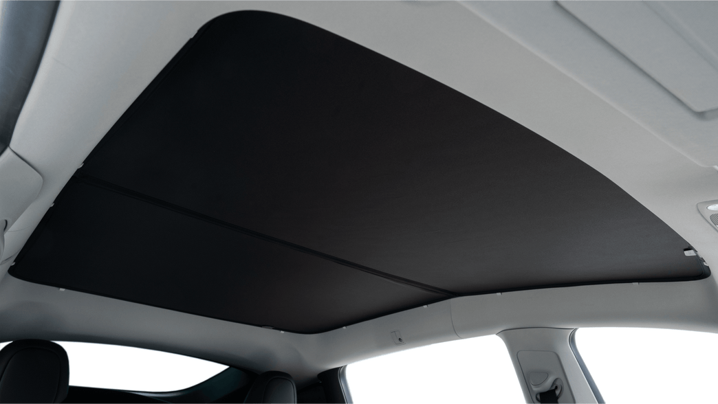 The interior view of a car displays the JOWUA All Model Y Glass Roof Sunshade (Juniper 2025+ / 2021-2024) made from mesh fabric, elegantly integrated into the ceiling. This design enhances aesthetics and offers UV protection, bordered by light-colored trim that complements the seats below.