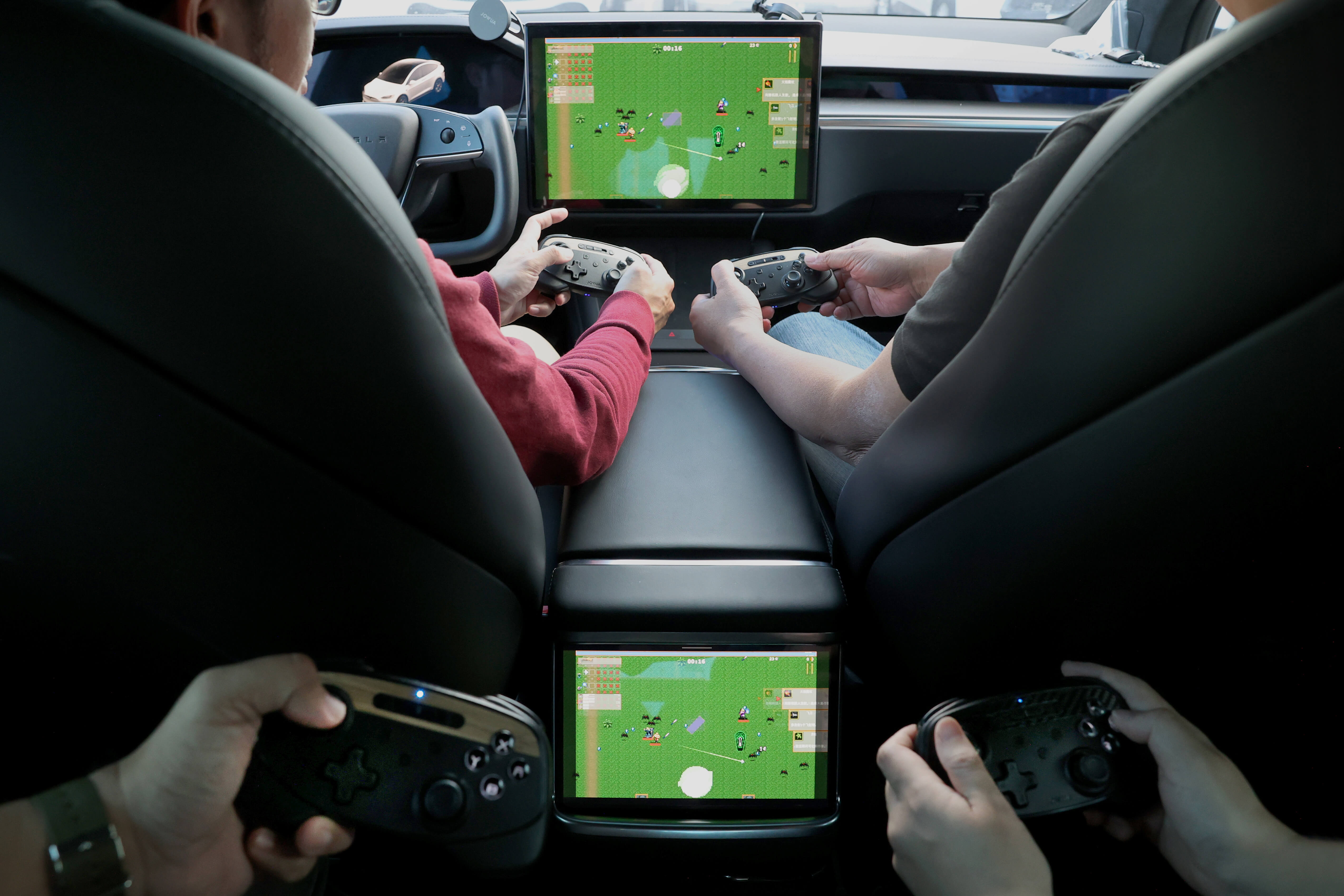 In a car with four passengers, they're enjoying video games on screens embedded in the seats using JOWUA's Tesla Gaming Controller—a multi-device wireless controller with Bluetooth connectivity. The controllers display a captivating green landscape filled with game characters, and the wireless charging feature ensures their devices remain powered for endless entertainment.