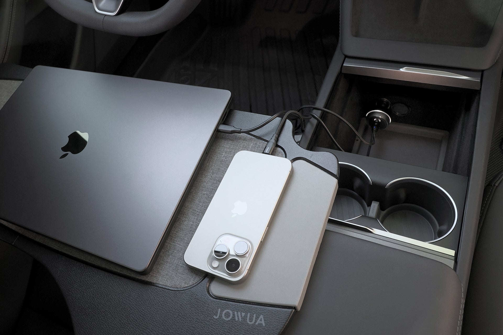 A JOWUA 165W PD3.1 Car Charger powers a MacBook and an iPhone on a Tesla