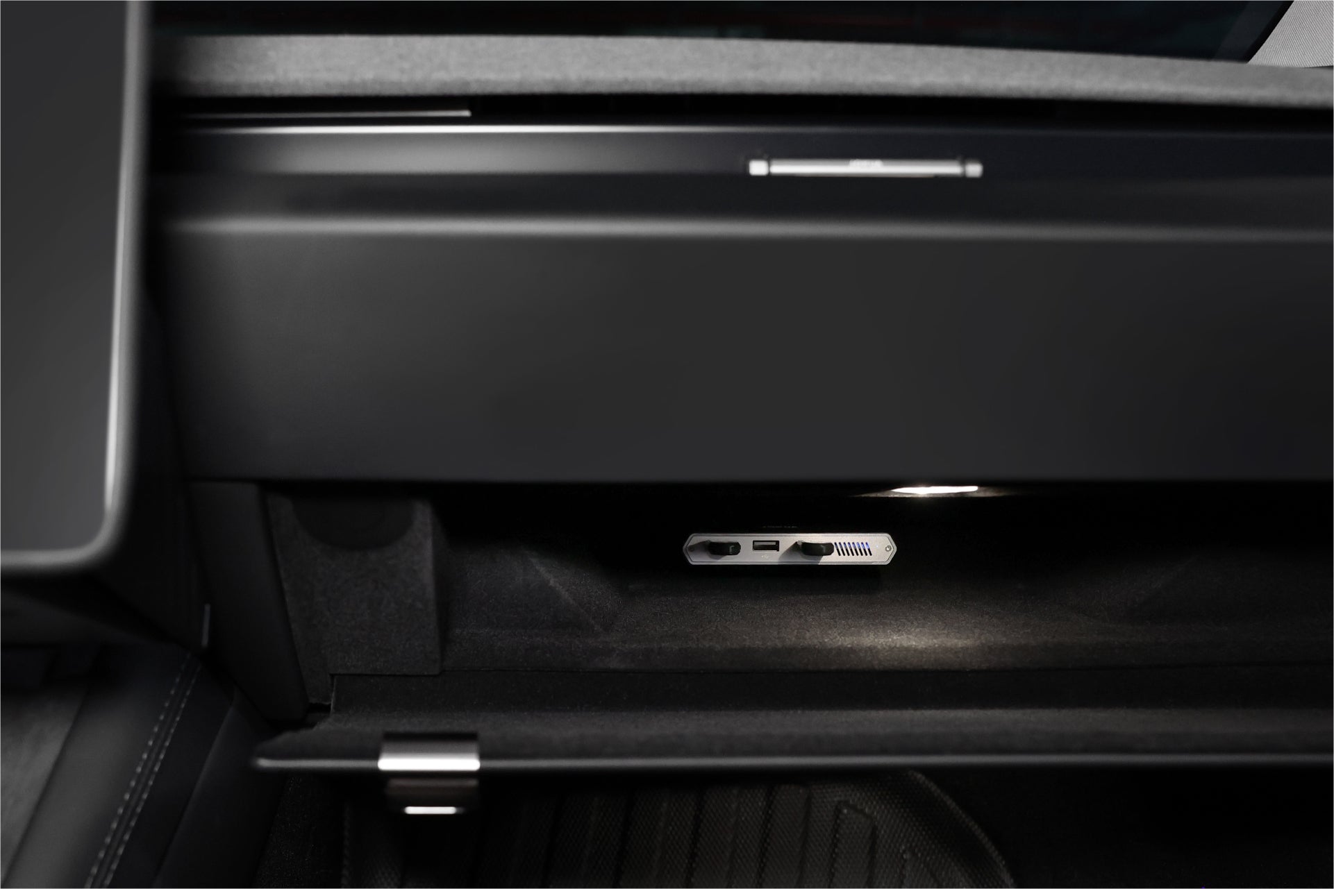Open the glove compartment of a car to reveal a JOWUA Tesla 1TB SSD + 3-Port HUB, with SD card slot and interior lighting—perfect storage for Sentry Mode devices.
