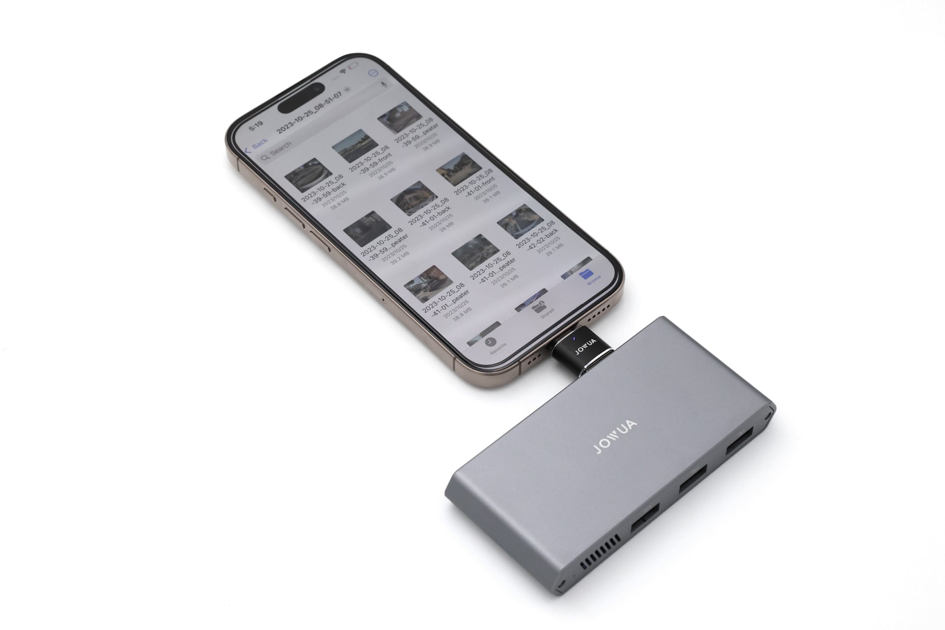 A smartphone connects to the JOWUA Tesla 1TB SSD + 3-Port HUB via an adapter, displaying a file manager—perfect for managing Tesla Sentry Mode storage. The gray hub with multiple ports sits on a white surface.