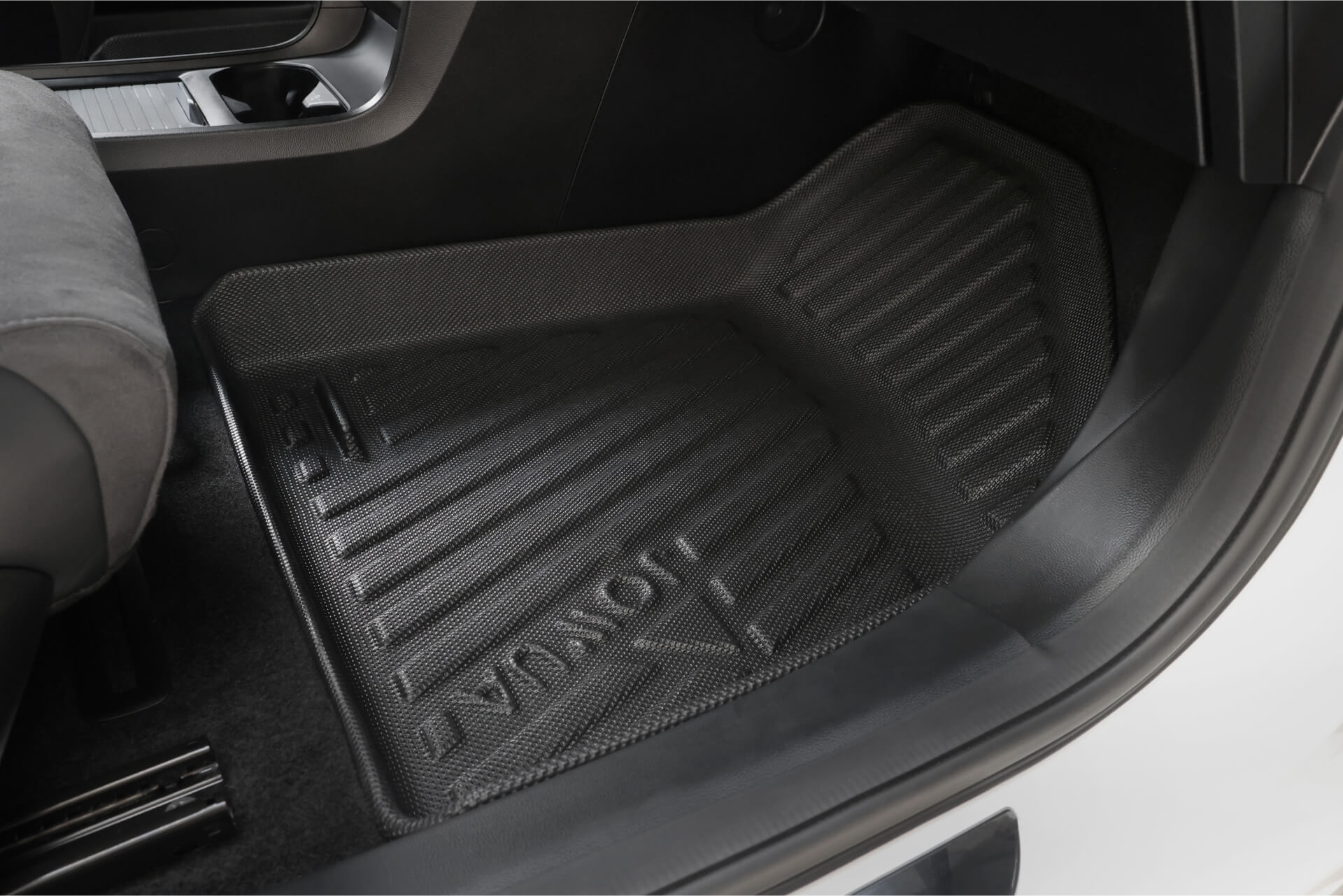 A close-up of a JOWUA All Weather Floor Liner (MG MG4) custom fit for the front passenger footwell, shown in a car with a dark interior.