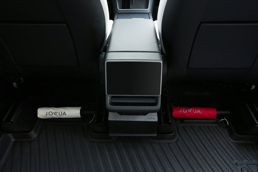 Two rolled-up umbrellas, one white and one red, are stored under the rear center console between two black seats on JOWUA All Model Y All-Weather Floor Liners Combo (Juniper 2025+ / 2021-2024).