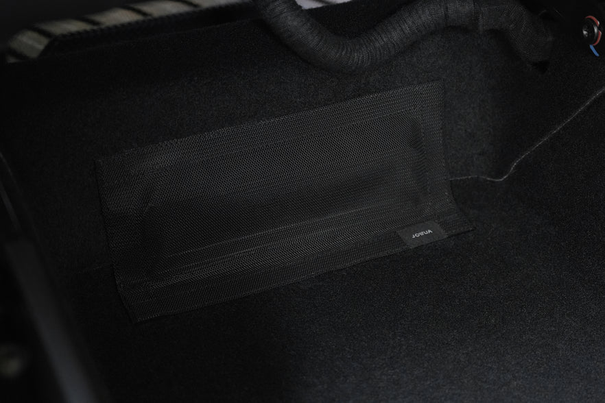 A close-up of a black mesh pocket, attached to the floor with a small “JOWUA” tag, highlights thoughtful storage featured with JOWUA All Model Y All-Weather Floor Liners Combo (Juniper 2025+ / 2021-2024).