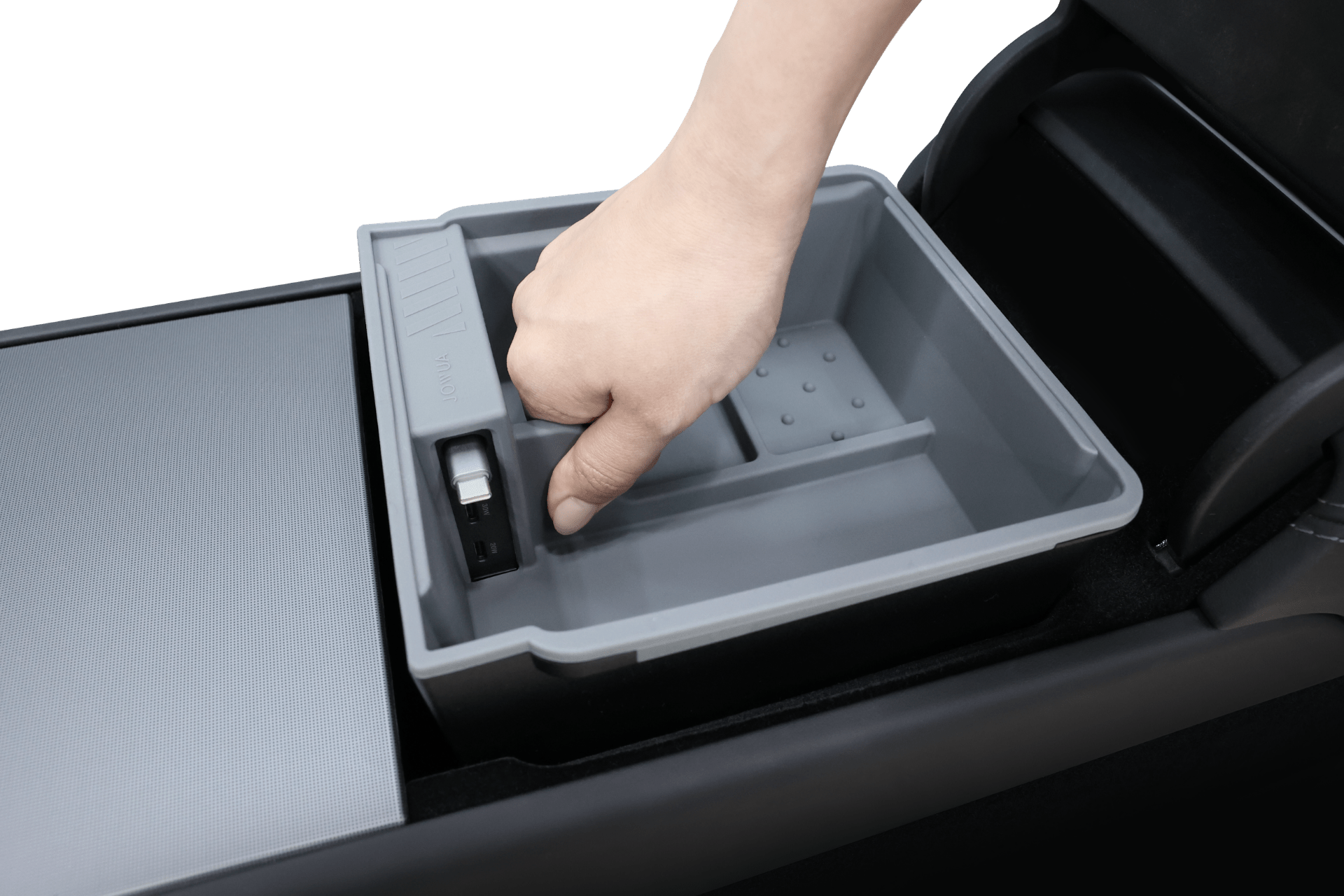 A hand lifts the JOWUA Center Console Organizer Set with Power HUB (Tesla Model 3 Standard 2026+) from a car’s black and gray center console compartment. The organizer tray has multiple storage sections and a small latch on one side.