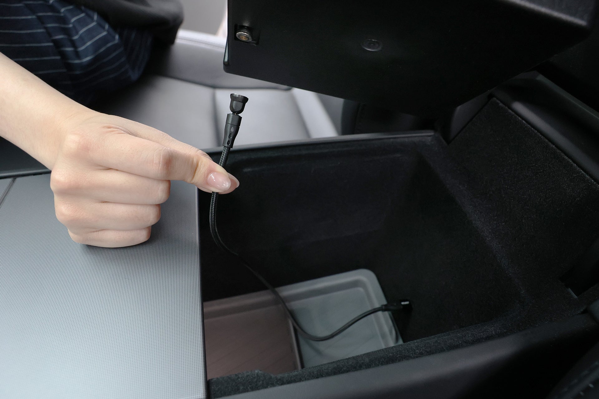 A hand pulls a flexible charging cable from the JOWUA Center Console Organizer Set with Power HUB, designed for Tesla Model 3 (2024-2026+), revealing an organized storage space in the car’s center console.