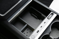 Close-up of the JOWUA Premium Interior Essentials Set (RHD) for Model Y Juniper, showing organized compartments, USB ports, a key card slot, and cup holders with a gray divider.