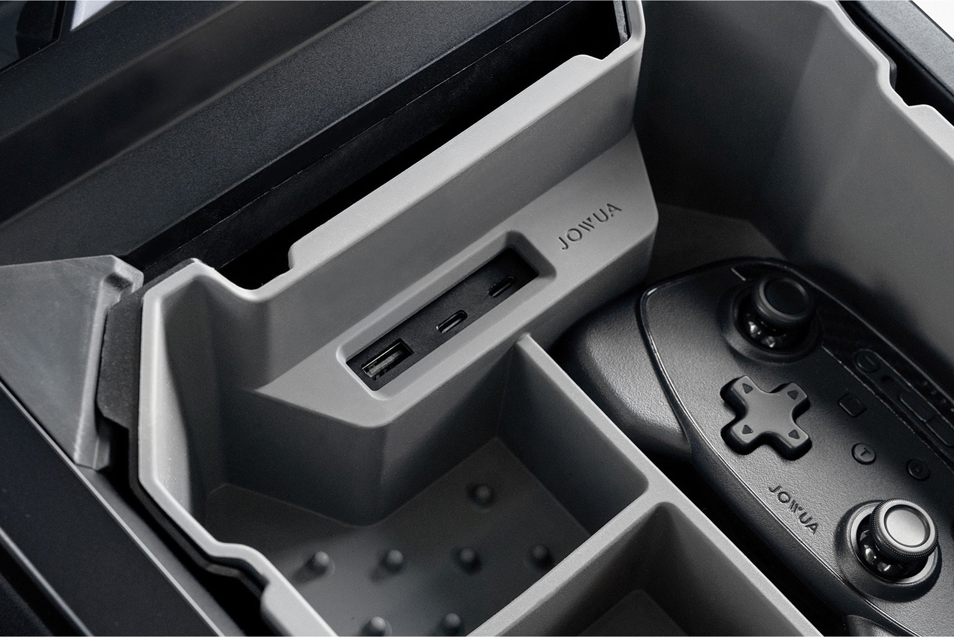 Close-up of the JOWUA Center Console Set for Tesla Cybertruck, showcasing molded slots with USB ports and a video game controller securely stored.