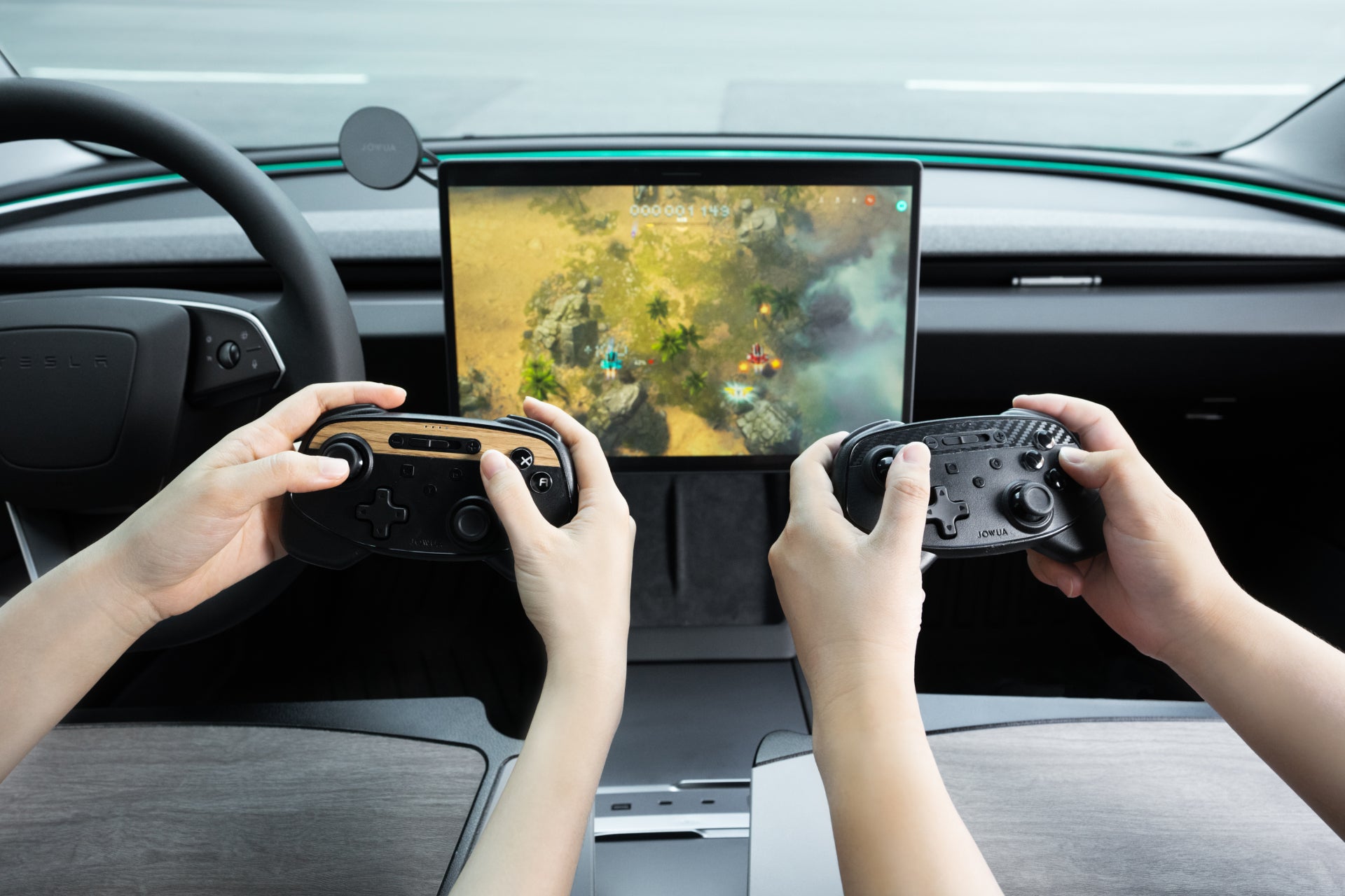 Two individuals with JOWUA Wireless Tesla Game Controllers are gaming on a screen inside a car. The Bluetooth Connect display shows a landscape with trees and characters, and the car's interior, including the steering wheel, is visible.