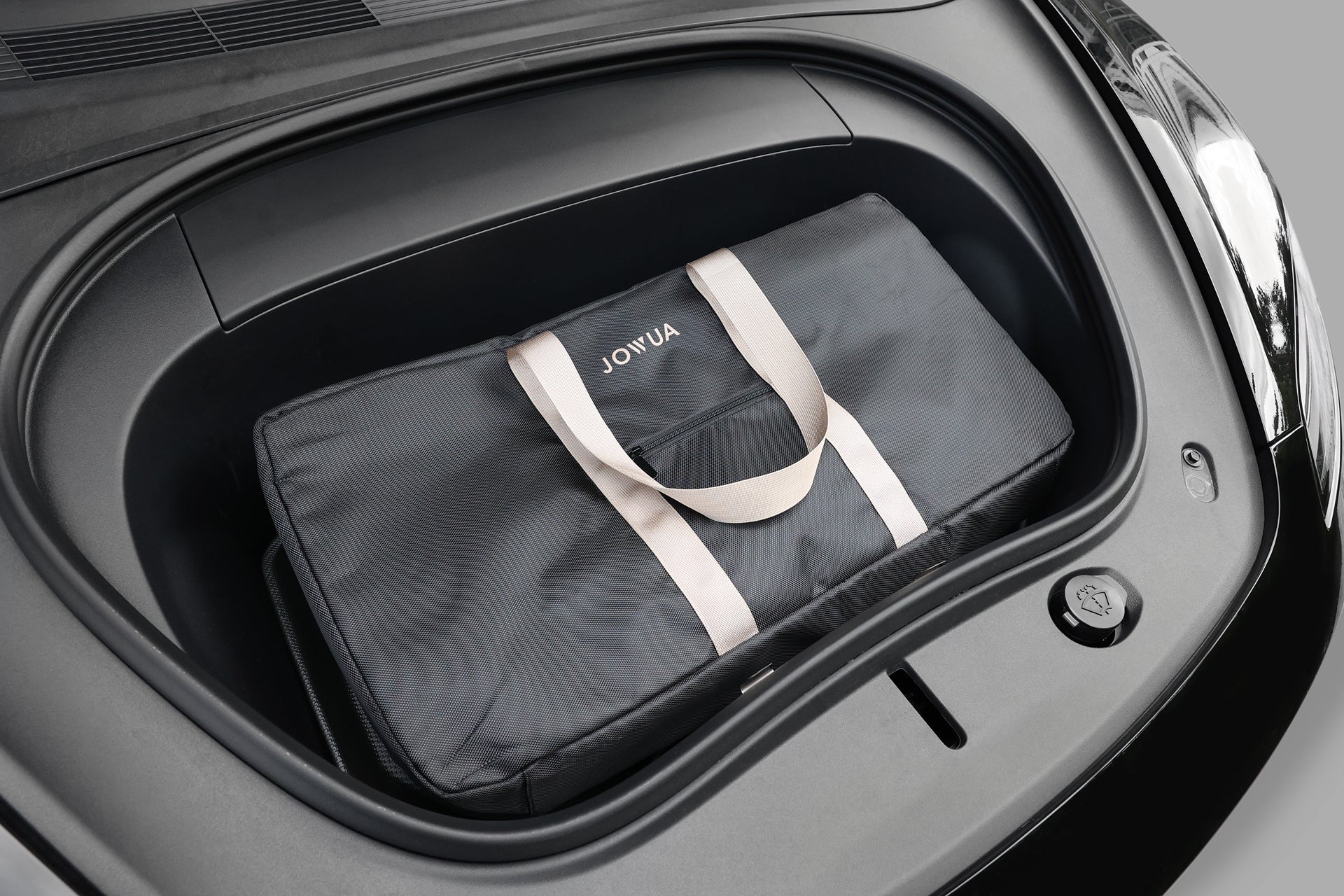 A JOWUA Folding Electric Scooter｜Performance fits neatly in the front trunk (frunk) of a black car, ready to elevate your next journey with innovative style and convenience.