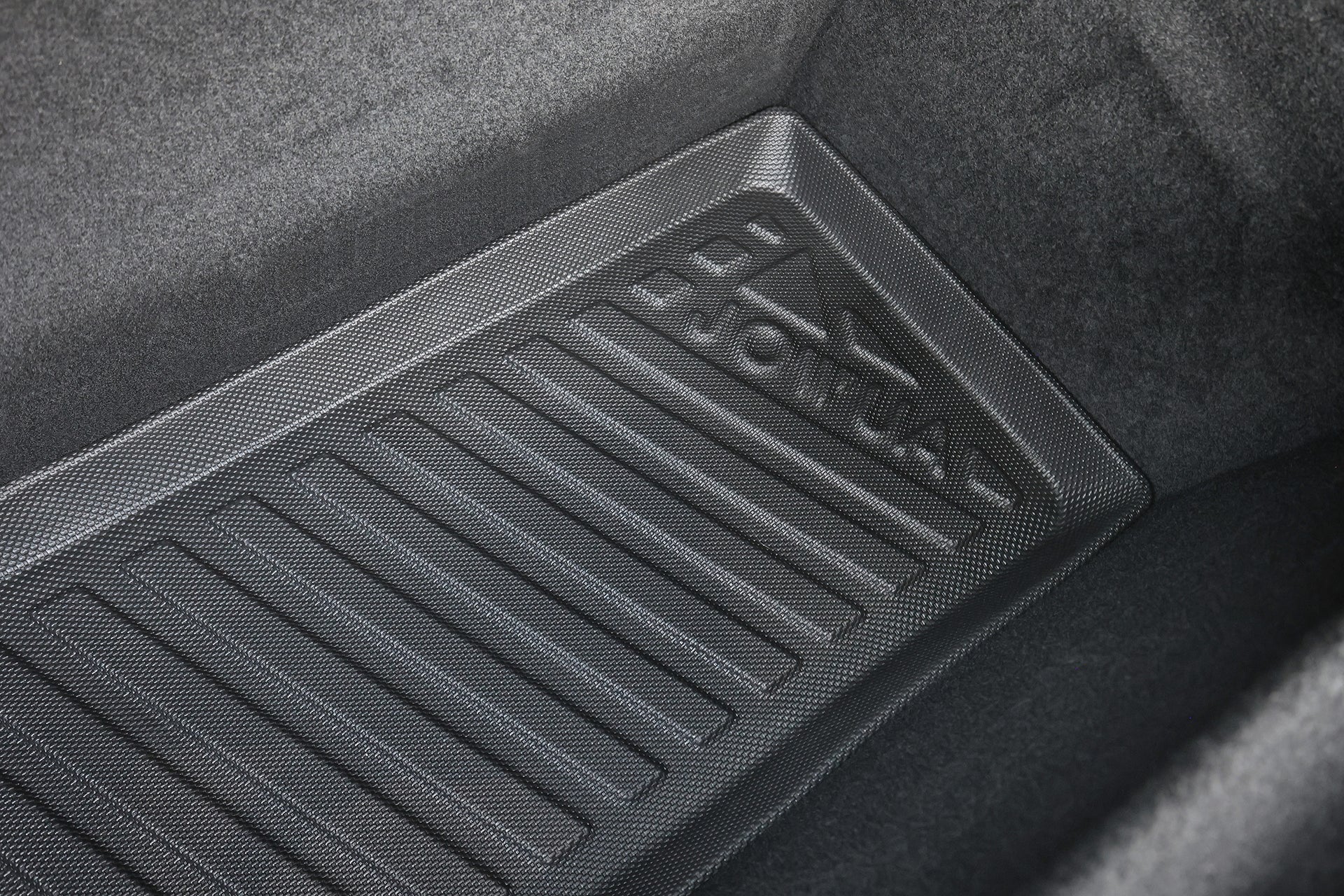 A close-up of the JOWUA All-Weather Shield Model X Trunk Liner (2021+), featuring a textured black TPE waterproof surface with "ROYAL" embossing, set against a dark car interior.