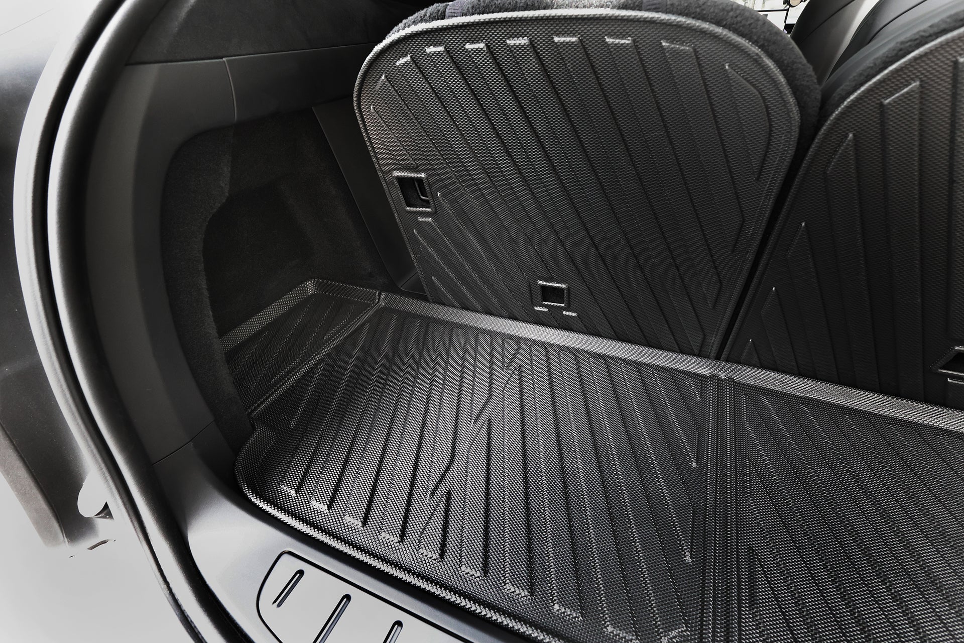 Close-up of the rear cargo area featuring the JOWUA All-Weather Shield | Model X Trunk Liners (2021+), a durable black textured TPE waterproof mat with folded back seats.