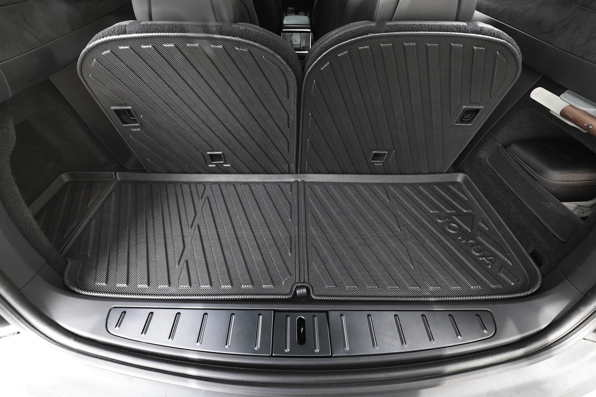 The image shows the trunk of a car with rear seats upright, fitted with JOWUA All-Weather Shield Model X Trunk Liners (2021+), designed to protect the trunk and seat backs.
