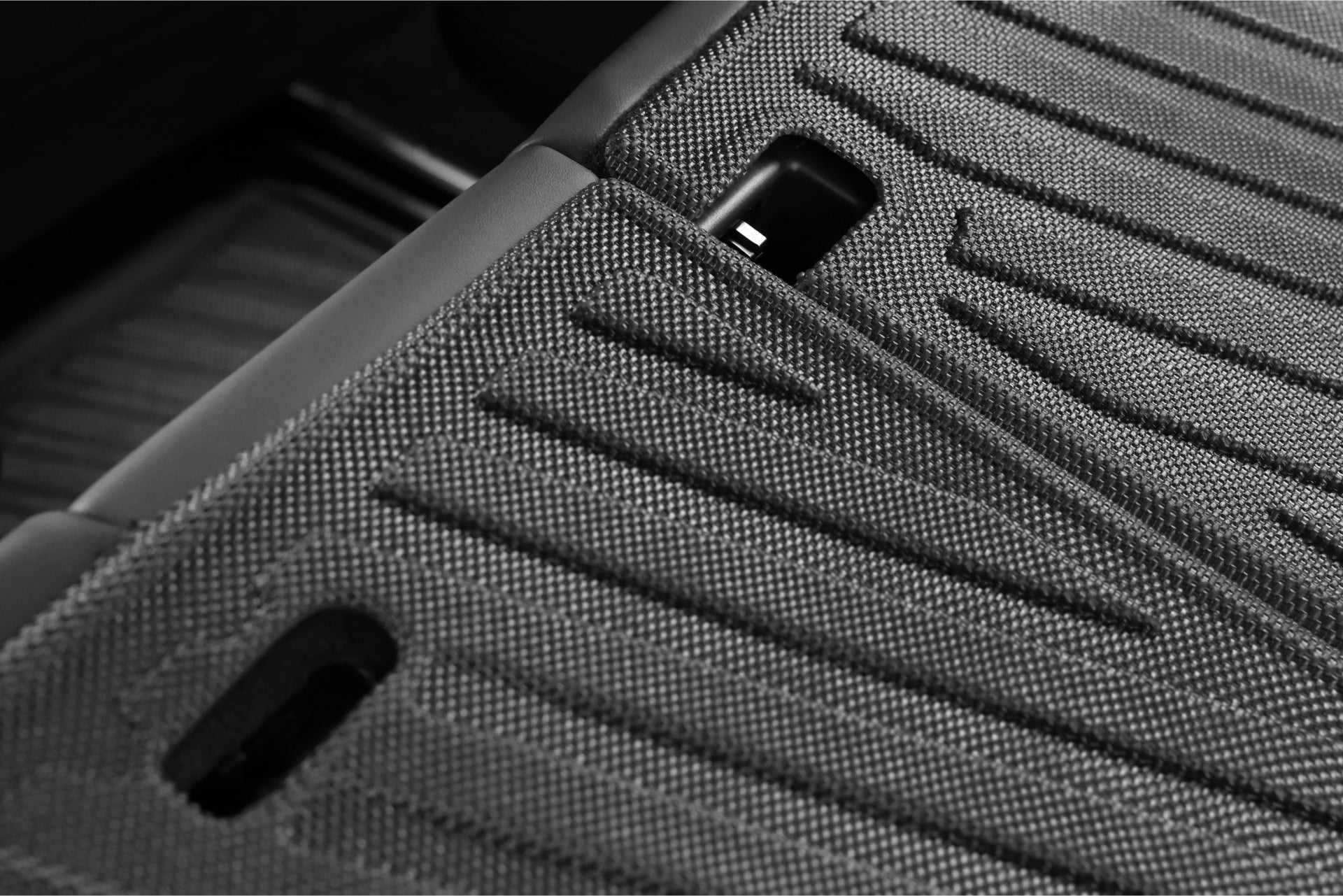 Close-up of textured black floor mats, part of the JOWUA Model 3 All Weather Trunk Combo for a reengineered Model 3 Highland (2024+), featuring visible grooves and cutouts overlapping each other. The image showcases the detailed pattern of waterproof TPE material, emphasizing durability and thoughtful design.