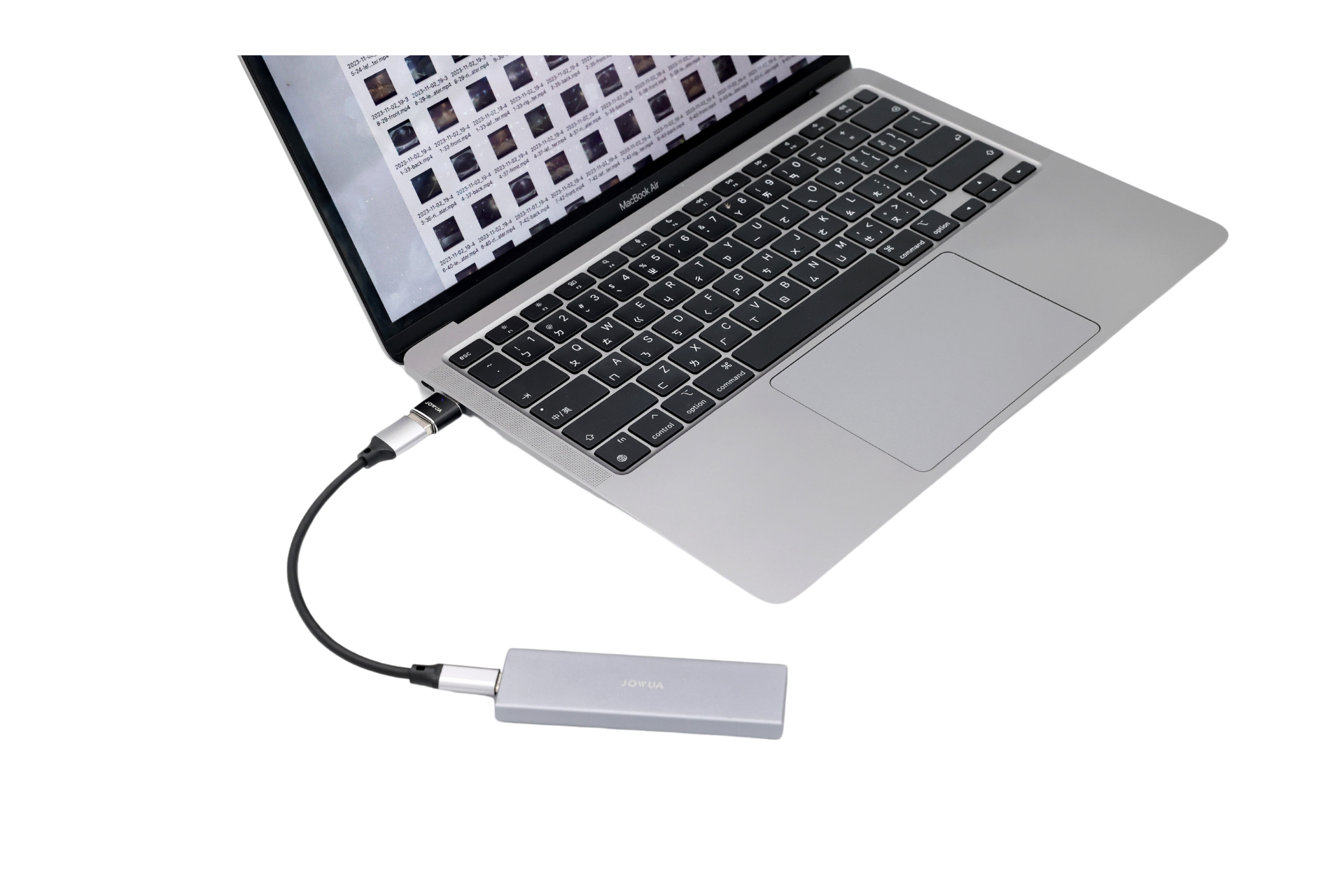 A silver laptop is connected to a JOWUA Sentry & DashCam Adapter Set OTG (USB-A to Type-C & Lightning) via a black USB-C cable, with the keyboard and touchpad visible, highlighting its dashcam and OTG functionality.