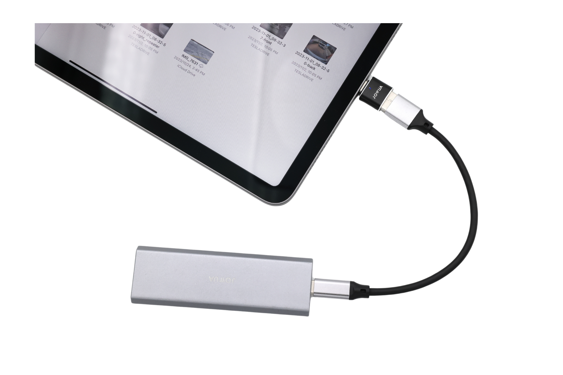 A JOWUA Sentry & DashCam Adapter Set OTG (USB-A to Type-C & Lightning) connects a tablet, via a black USB-C cable, to a silver external device. The tablet screen shows multiple image thumbnails.