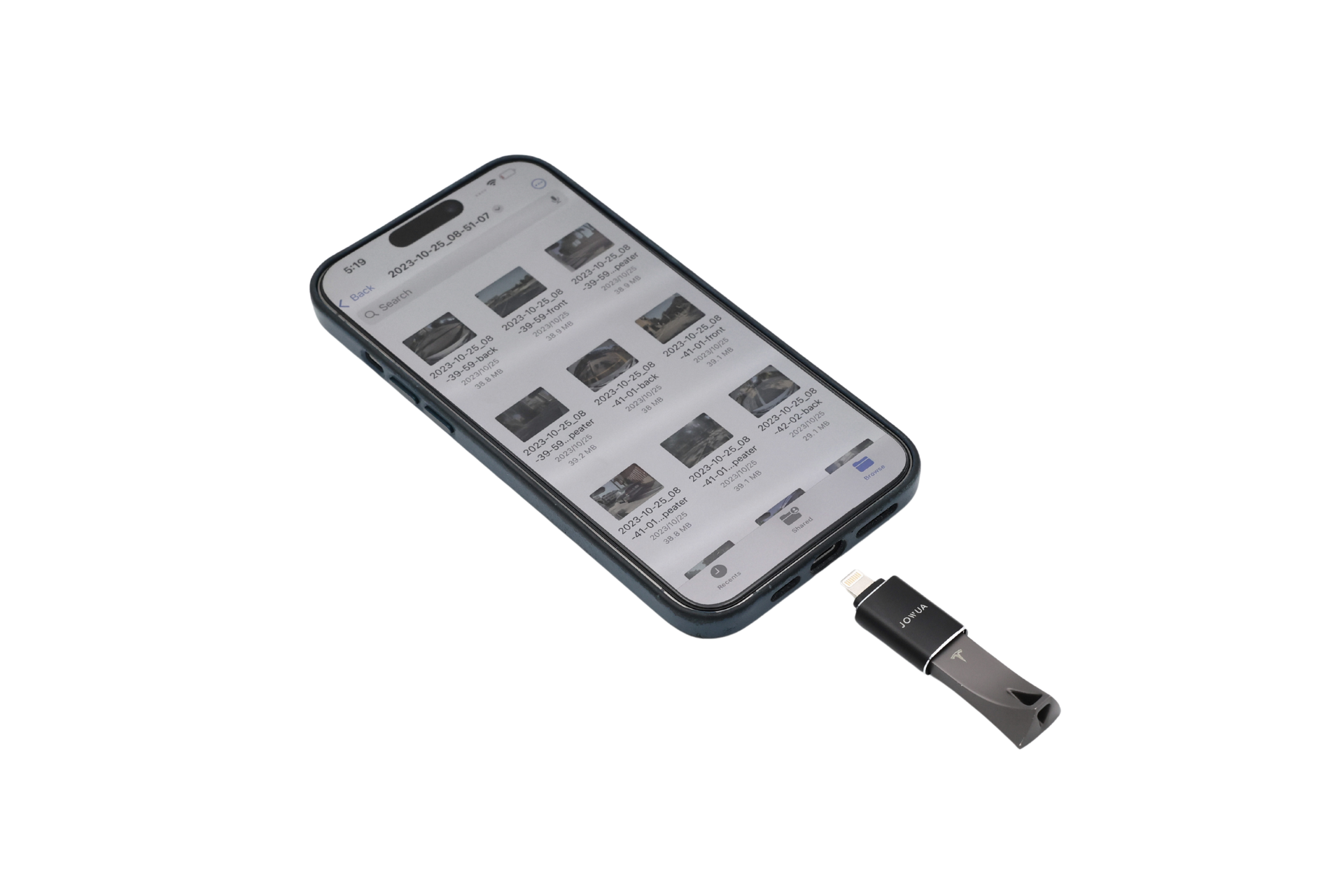 A smartphone displays files while connected to a Sentry & DashCam Adapter Set OTG (USB-A to Type-C & Lightning) by JOWUA, linking it to a black Tesla dashcam USB flash drive.