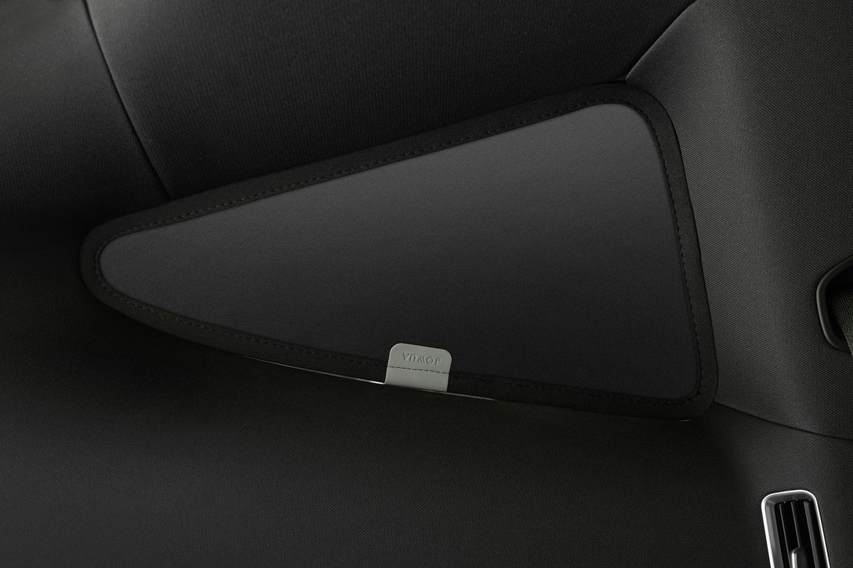 Close-up of a black, triangular interior car panel featuring a silver “VIVALDI” label at the center and a partial air vent on the right, highlighting the sleek fit of the JOWUA Side + Rear Lift Gate Window Sunshade for Model Y L (2026+) designed for optimal coverage.
