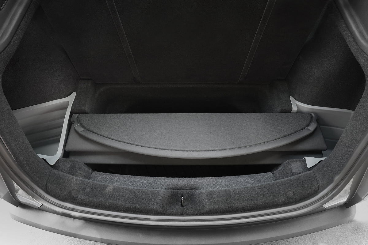 Open trunk of a car displaying an empty cargo area with a retractable cover, gray carpeting, plastic side panels, and JOWUA Model Y 2025+ Interior / Trunk Full Coverage Liner Combo for enhanced protection.