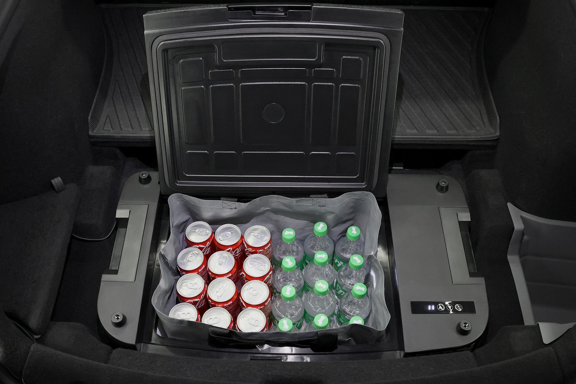 The JOWUA Car Refrigerator for Tesla Model Y features a built-in cooler with intelligent dual-mode cooling, neatly storing red soda cans and clear water bottles with green caps in two rows.