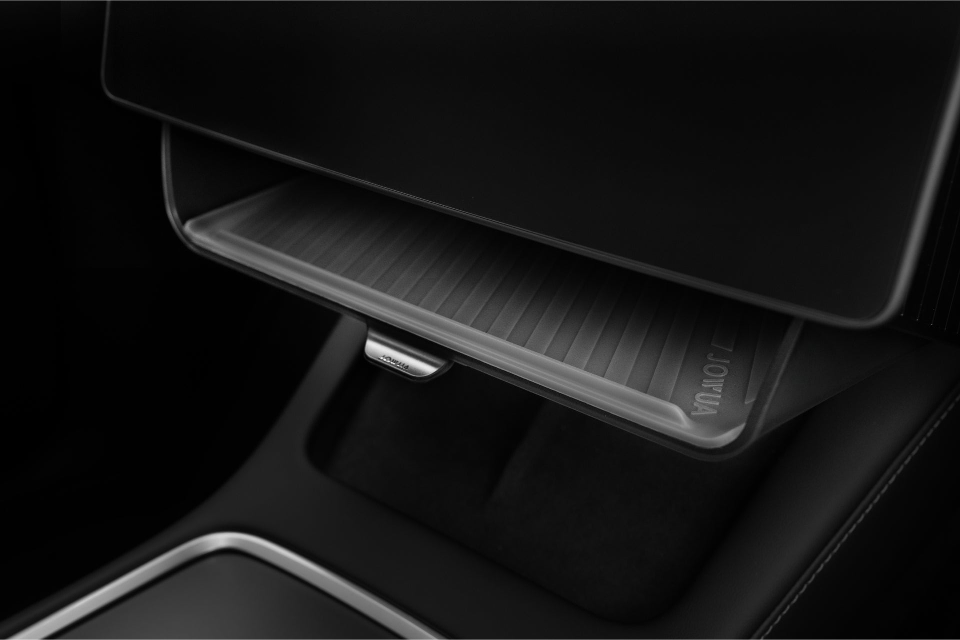A close-up of JOWUA’s Under Screen Invisible Station in a Model 3 Highland (2024+) shows the open glove compartment with its textured mat, surrounded by sleek, dark interior surfaces that emphasize a minimalist and modern aesthetic.