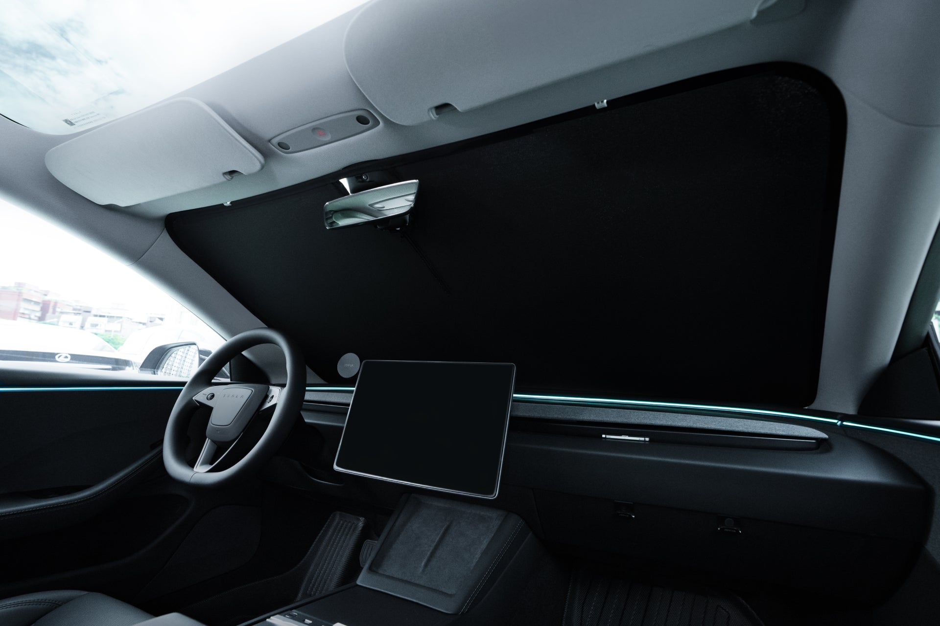 The interior of a modern vehicle, like those equipped with the JOWUA Windshield Sunshade for all Model 3 versions (M3 / M3HL / M3HL Performance), features a sophisticated dashboard complete with an expansive central touchscreen. A dark-tinted windshield sunshade offers UV protection, enhancing its minimalist design and underscoring its emphasis on technology and clean lines.