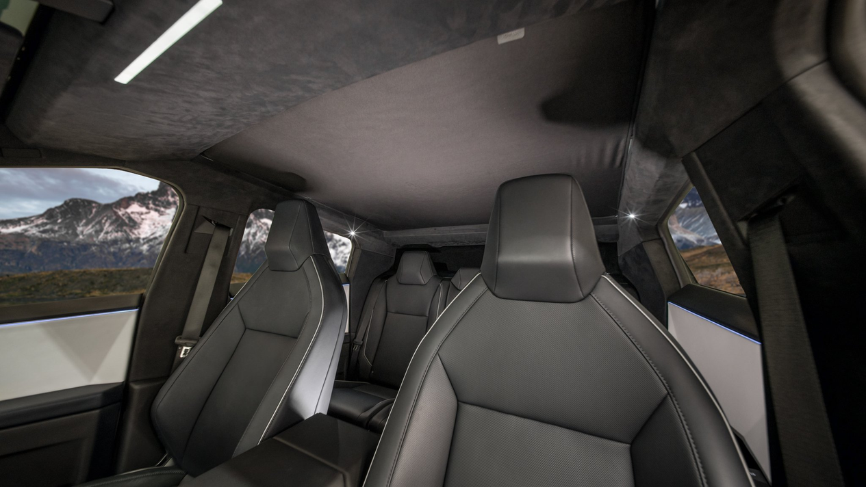 Interior view of a luxury vehicle showcasing sleek black leather seats enhanced by mesh fabric accents. Modern design elements frame the windows, revealing a scenic mountain view through the JOWUA Cybertruck Glass Roof Sunshade known for its excellent UV protection.