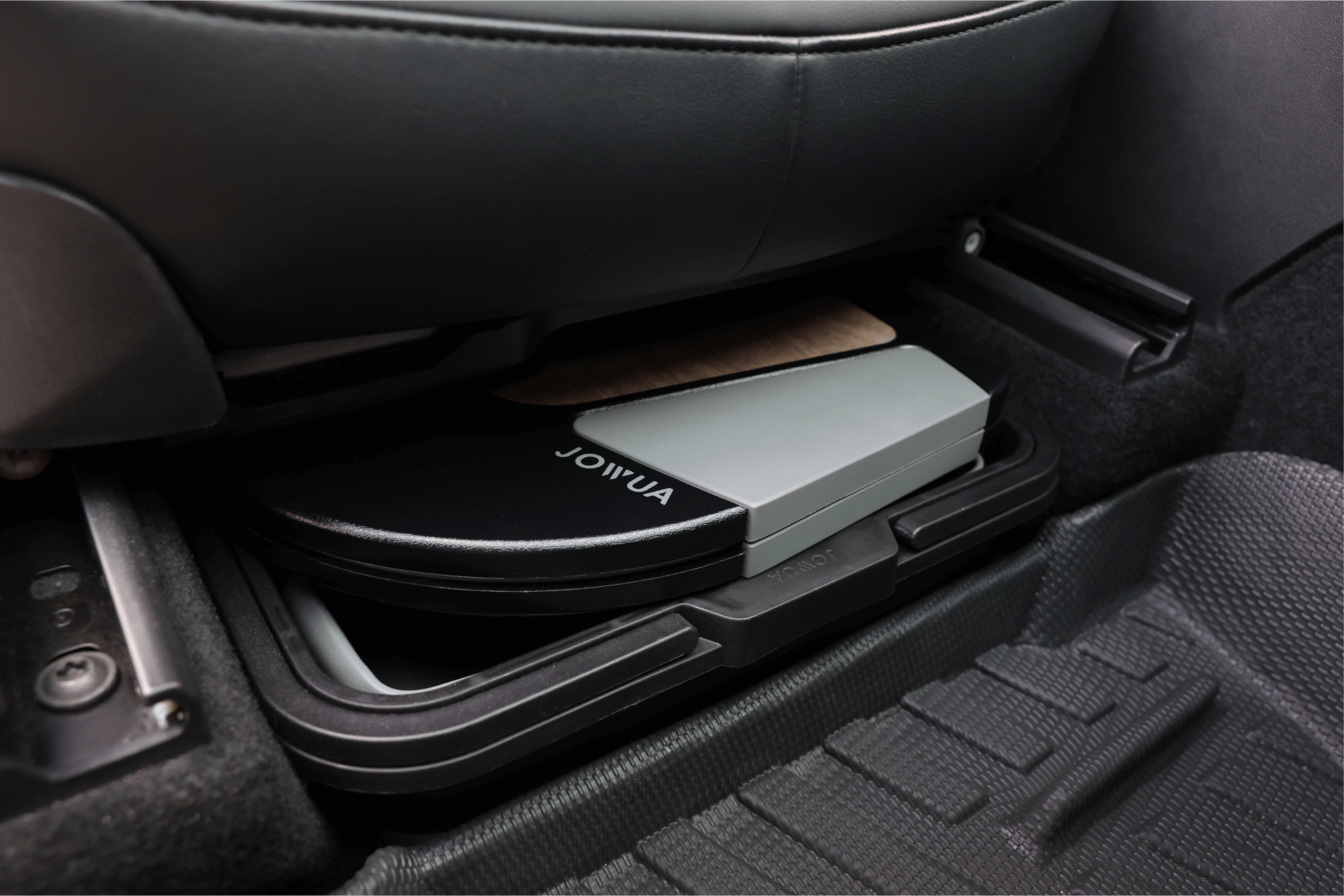 A Foldable Car Tray Bundle from JOWUA, featuring a portable design, is conveniently stored beneath the seat of a Tesla Model S.