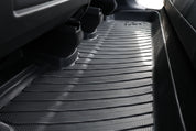 Close-up of a JOWUA Premium Interior Essentials Set (RHD) – Model Y Juniper all-weather black floor mat, textured for grip, covering the rear area and extending under seats to protect the premium interior from dirt and moisture.