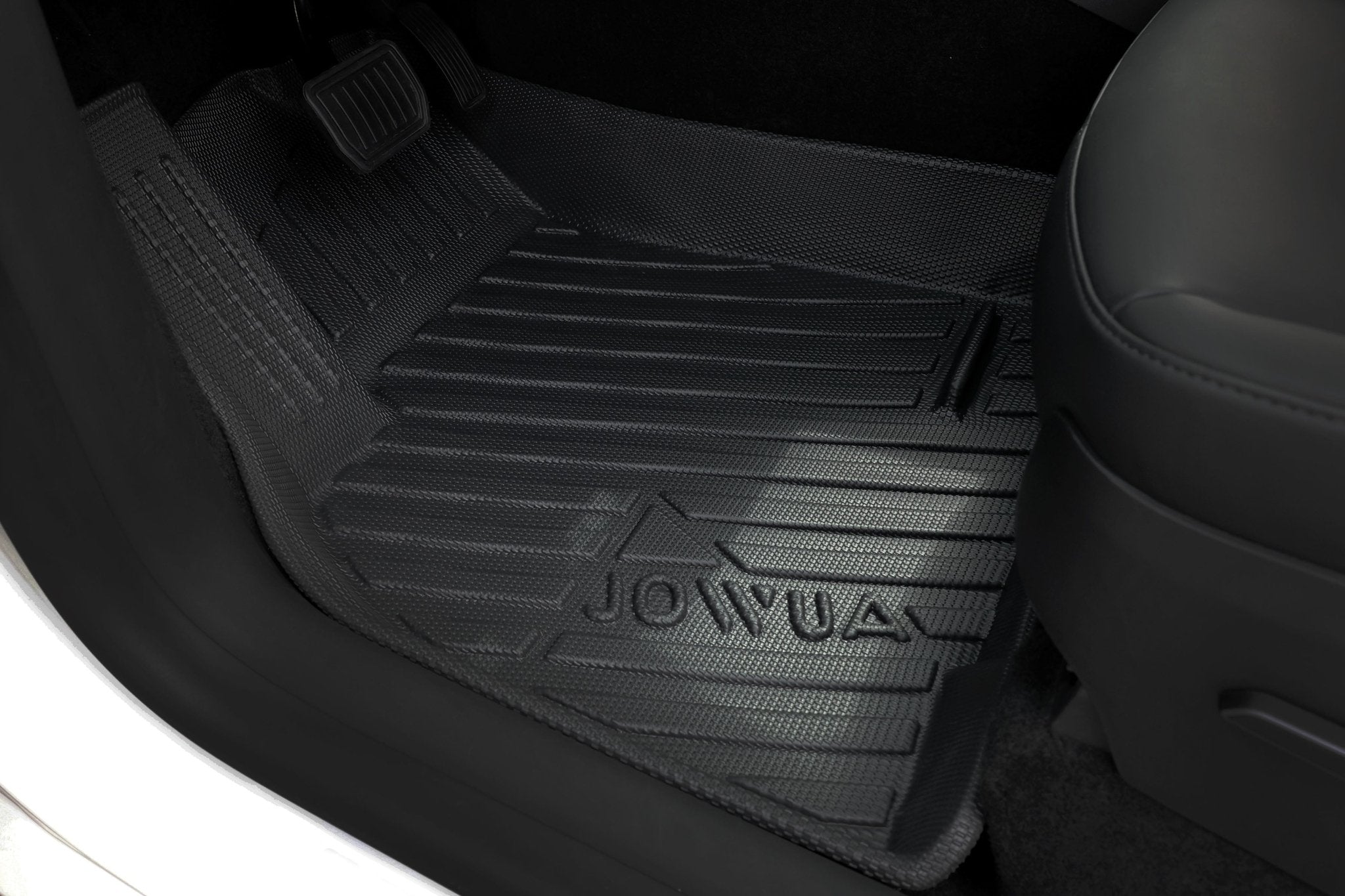 A close-up of the JOWUA Premium Interior Essentials Set (RHD) for Model Y Juniper (2025+) highlights a textured, all-weather floor mat beneath the pedals and front seat, combining durability with style for your Tesla’s interior.