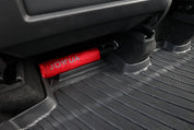 A red foldable umbrella with "JOWUA" rests under a car seat on Model Y All-Weather Floor Liners Combo - Juniper Compatible (Right Hand Drive Version), perfect Tesla Model Y accessories.