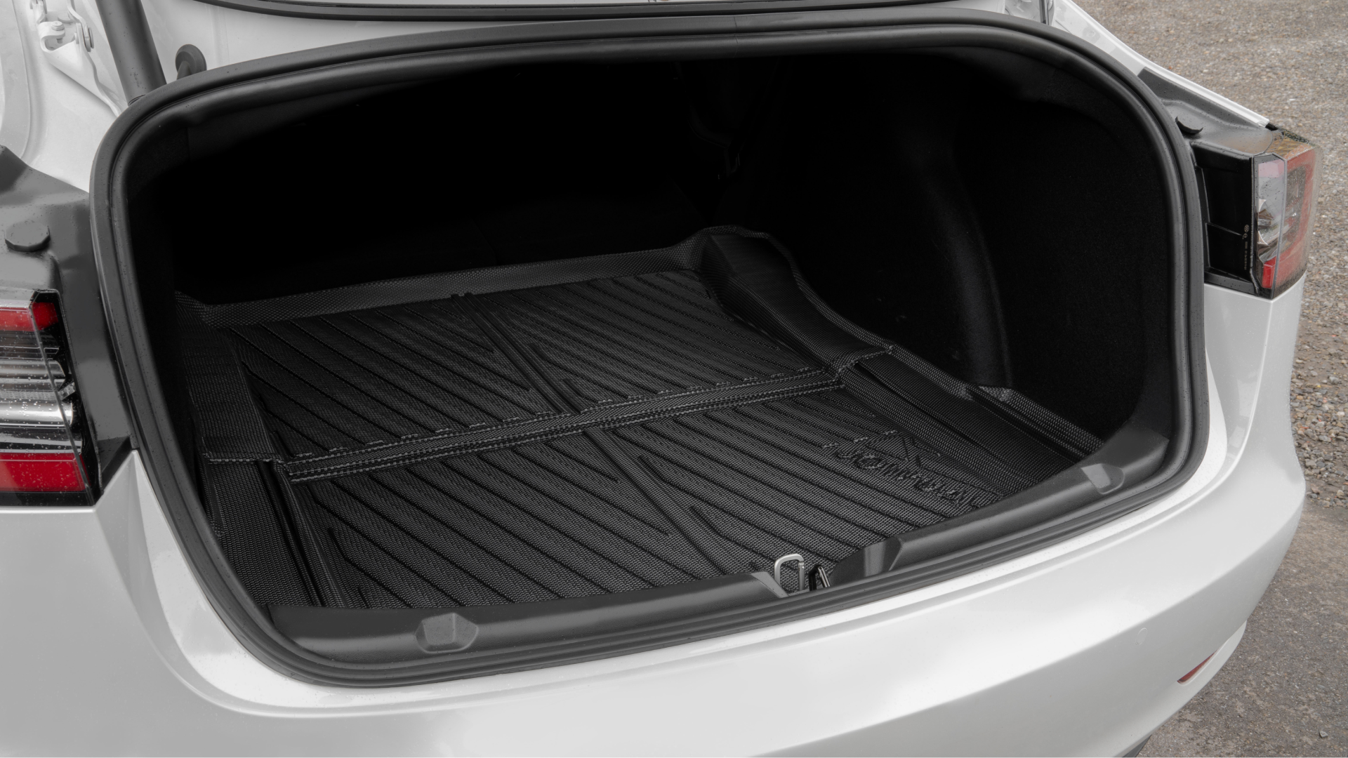 Lift the trunk lid of a white Tesla Model 3, unveiling a roomy, unoccupied cargo space outfitted with JOWUA