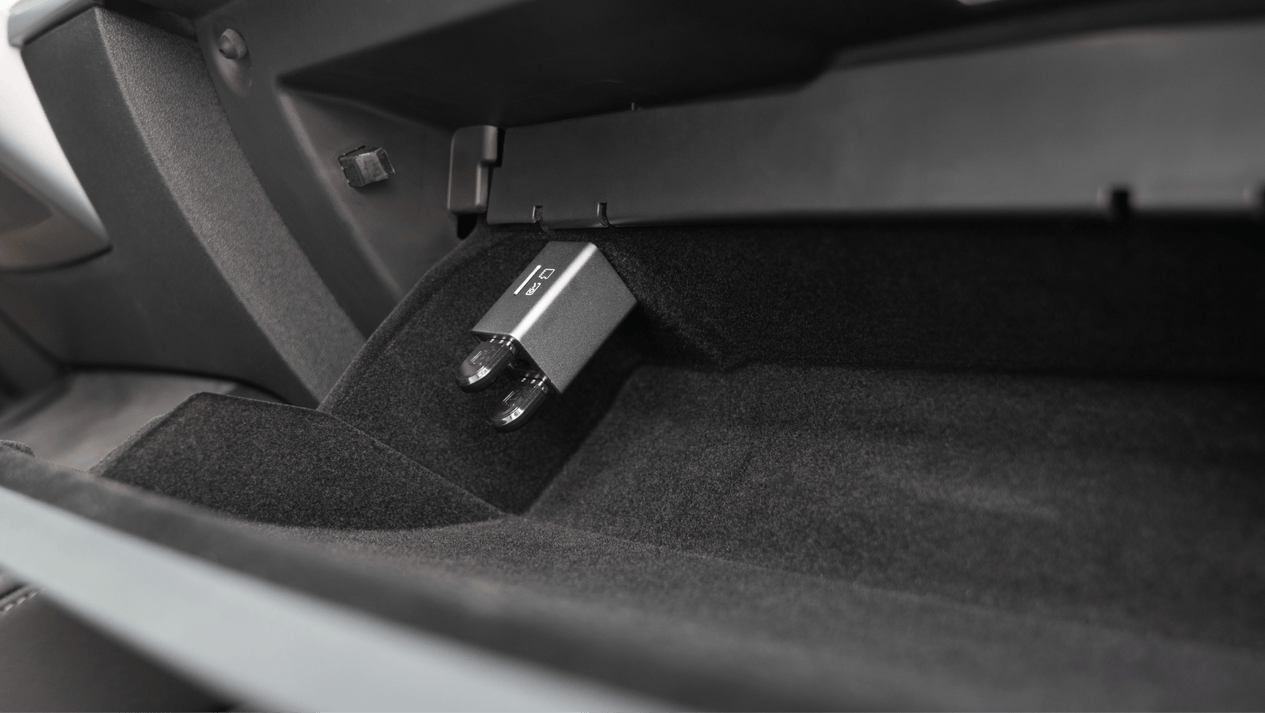The image features a car glove compartment with a JOWUA 3 Port USB HUB with DashCam Reader inserted into the port. The interior is lined with black fabric and plastic, adding a sleek touch to this Tesla USB hub setup.