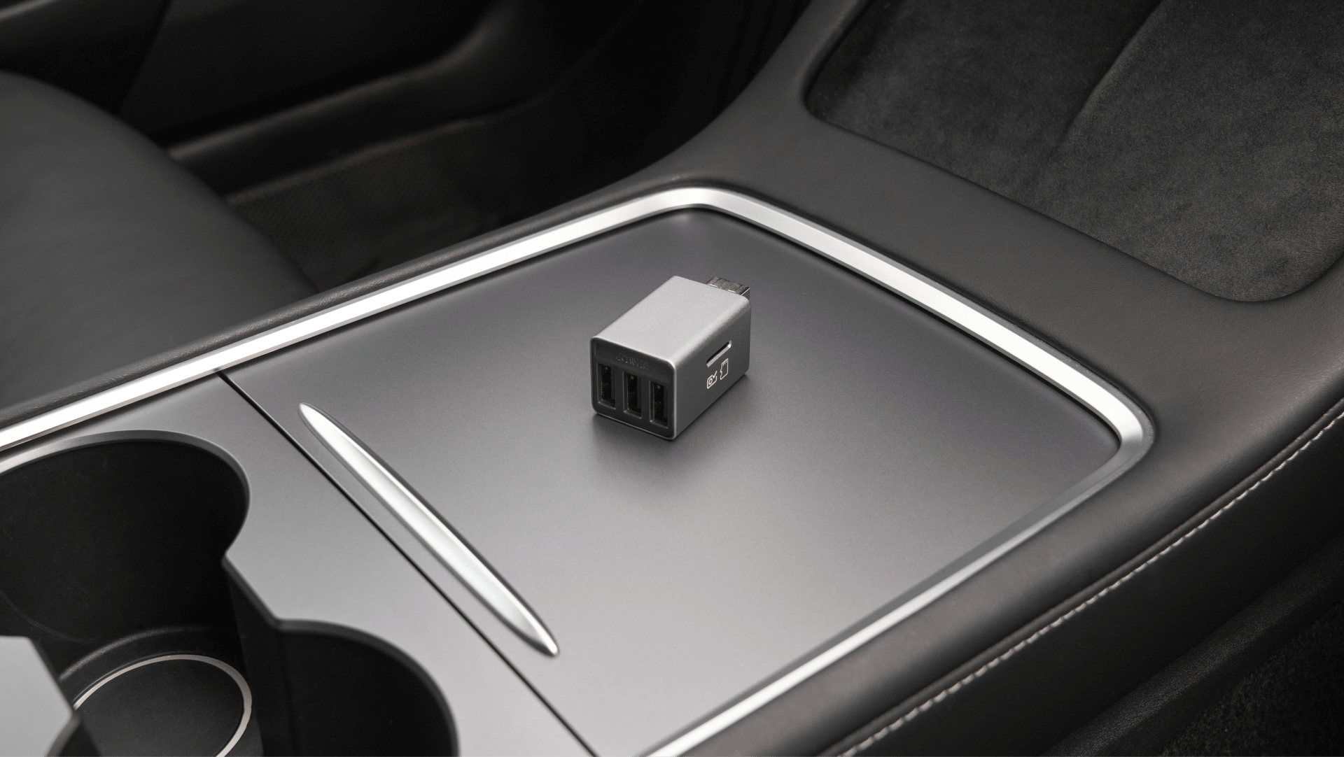 A USB car charger with two ports sits on the stylish JOWUA 3 Port USB HUB with DashCam Reader within the vehicle