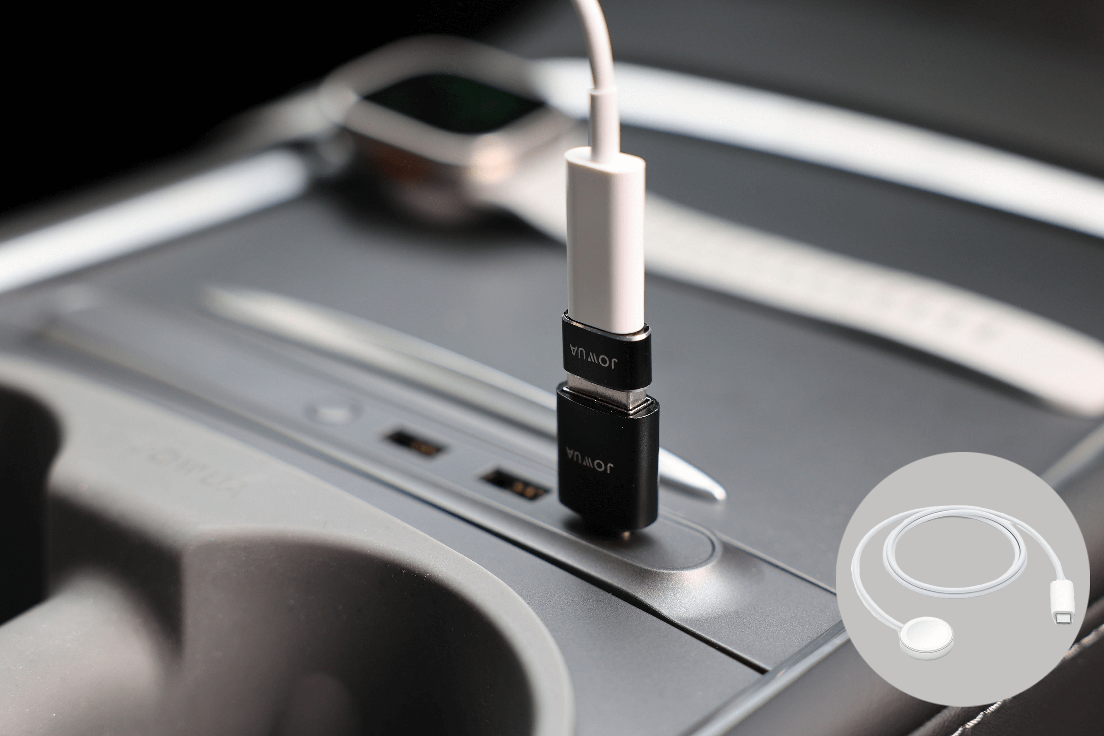 A close-up of a car interior shows the JOWUA Apple Watch Tesla Charging Kit connected via a USB-C to USB-A adapter plugged into a USB port. In the background, there