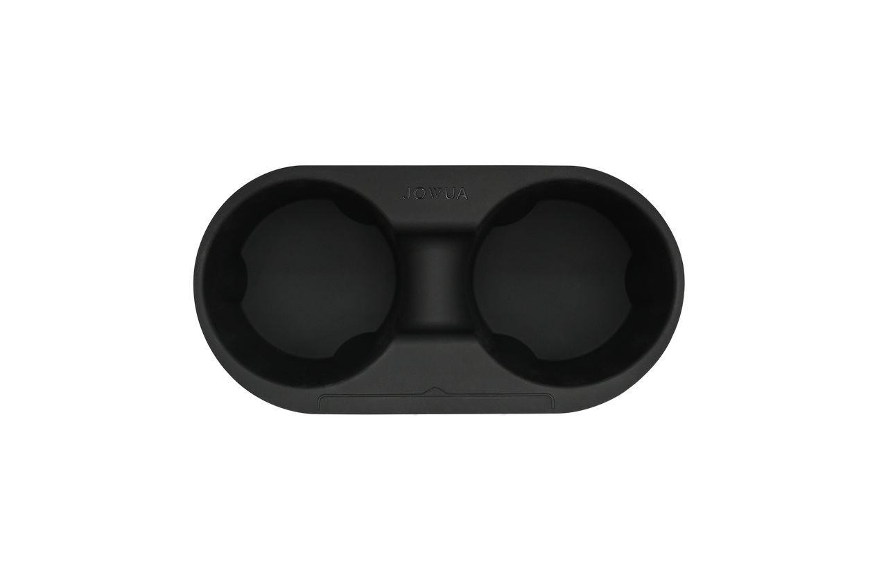 Introducing the JOWUA Center Console Cup Holder for Tesla Model 3 and Model Y: a black, oval-shaped double holder made from smooth silicone, equipped with a central divider. This cup holder is perfect for the center console and features rounded indentations with a subtle texture along its inner rims.