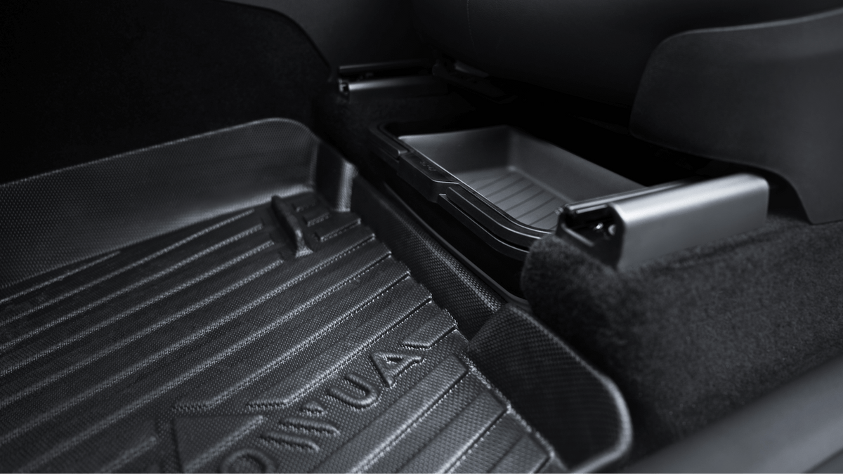 Close-up of a Tesla Model X/Y backseat floor with a textured all-weather mat and JOWUA Under Seat Collapsible Organizer (Set of 2) next to a small storage tray.