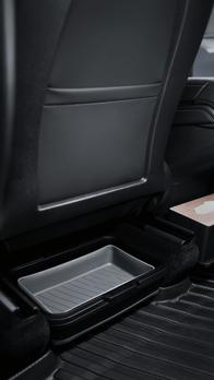 The car interior boasts a rear passenger seat with black leather upholstery. Beneath the seat, you