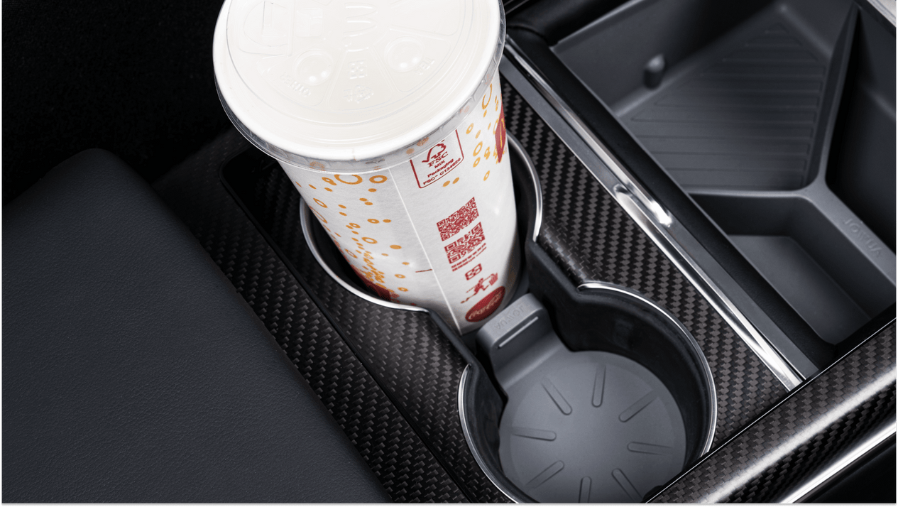 A large soft drink cup with a white lid fits neatly in a car