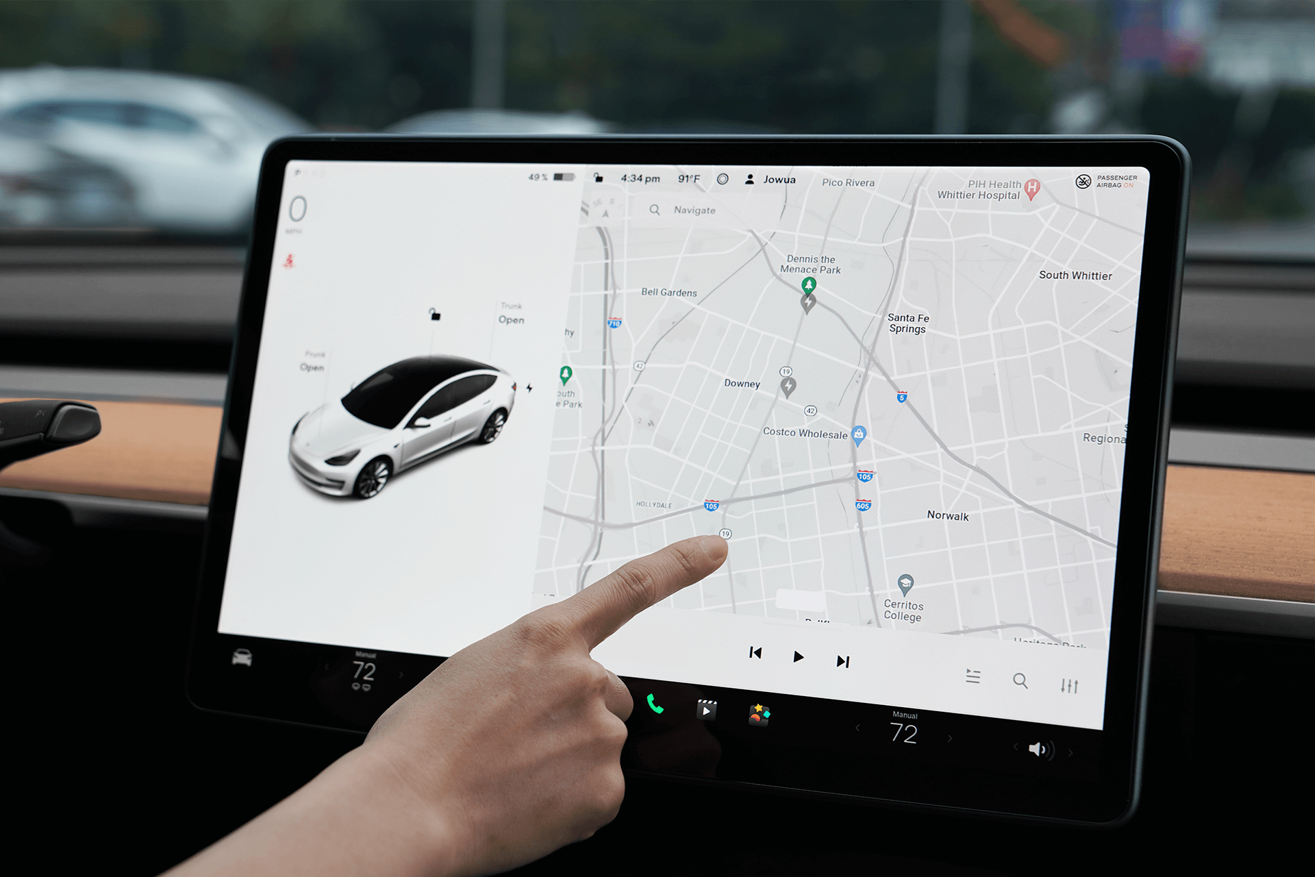 A hand interacts with the dashboard touchscreen of a Tesla Model 3/Y, displaying a map on the right and a car image on the left. The interface, safeguarded by a JOWUA Tempered Glass Screen Protector, shows navigation details. The modern interior is accented with a wooden panel and control icons.